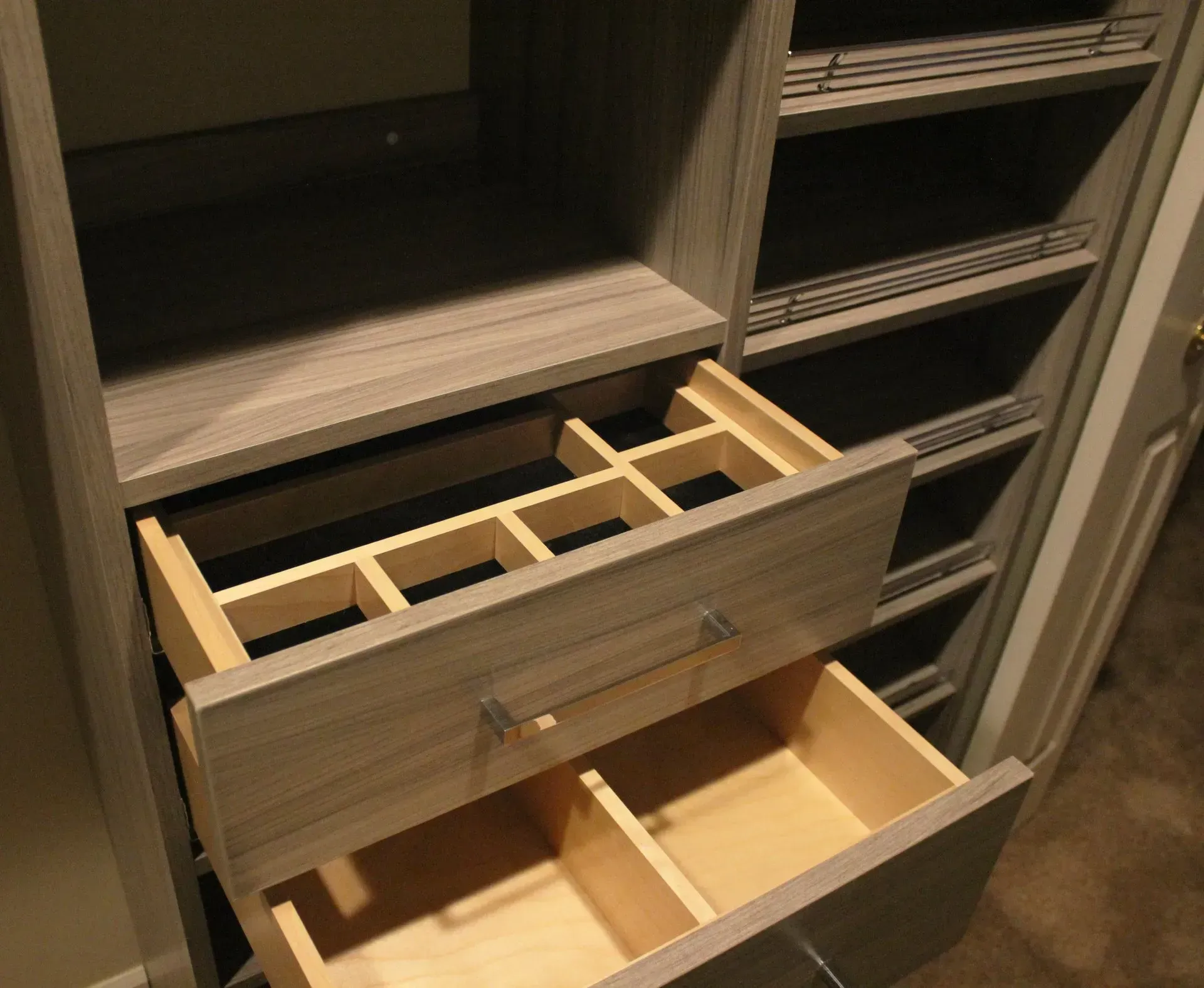 Open drawer with wooden organizer dividers inside a light wood closet unit In Bucks Country PA
