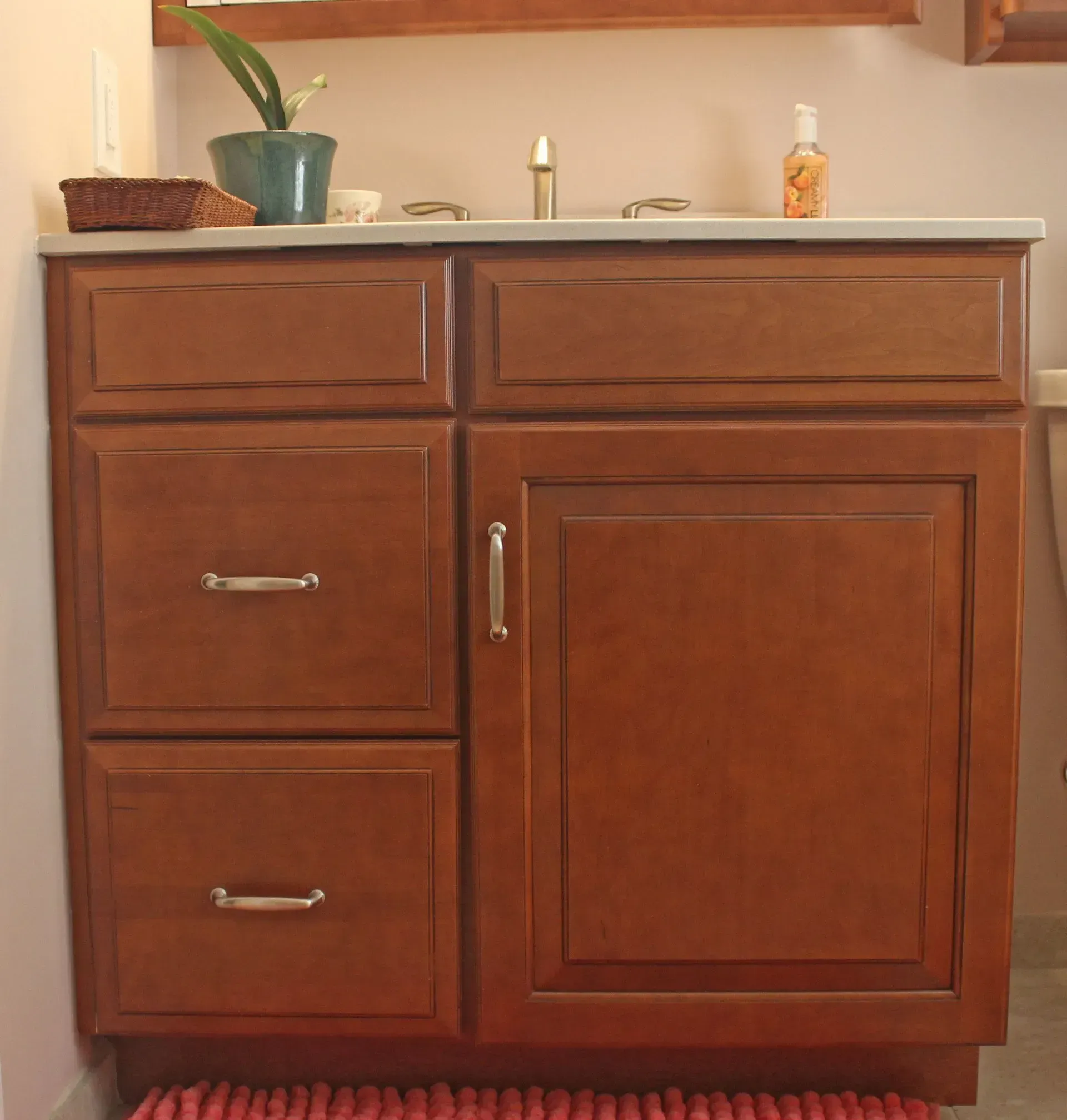 Wooden bathroom vanity with sink, drawers, and cabinet under a light countertop In Bucks County PA