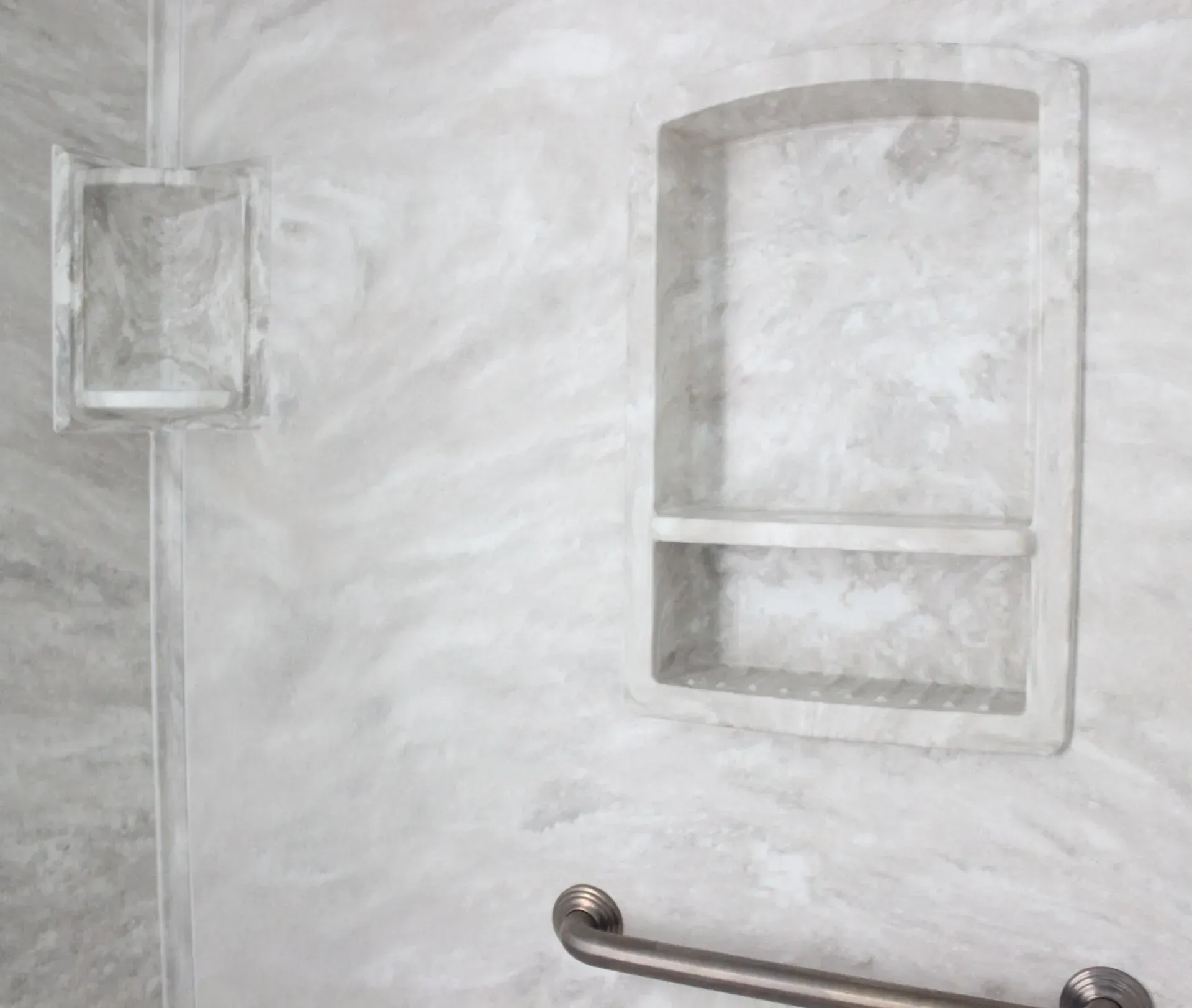 Gray bathroom wall with a small shelf and a towel bar beneath a mirrored cabinet In Bucks County PA