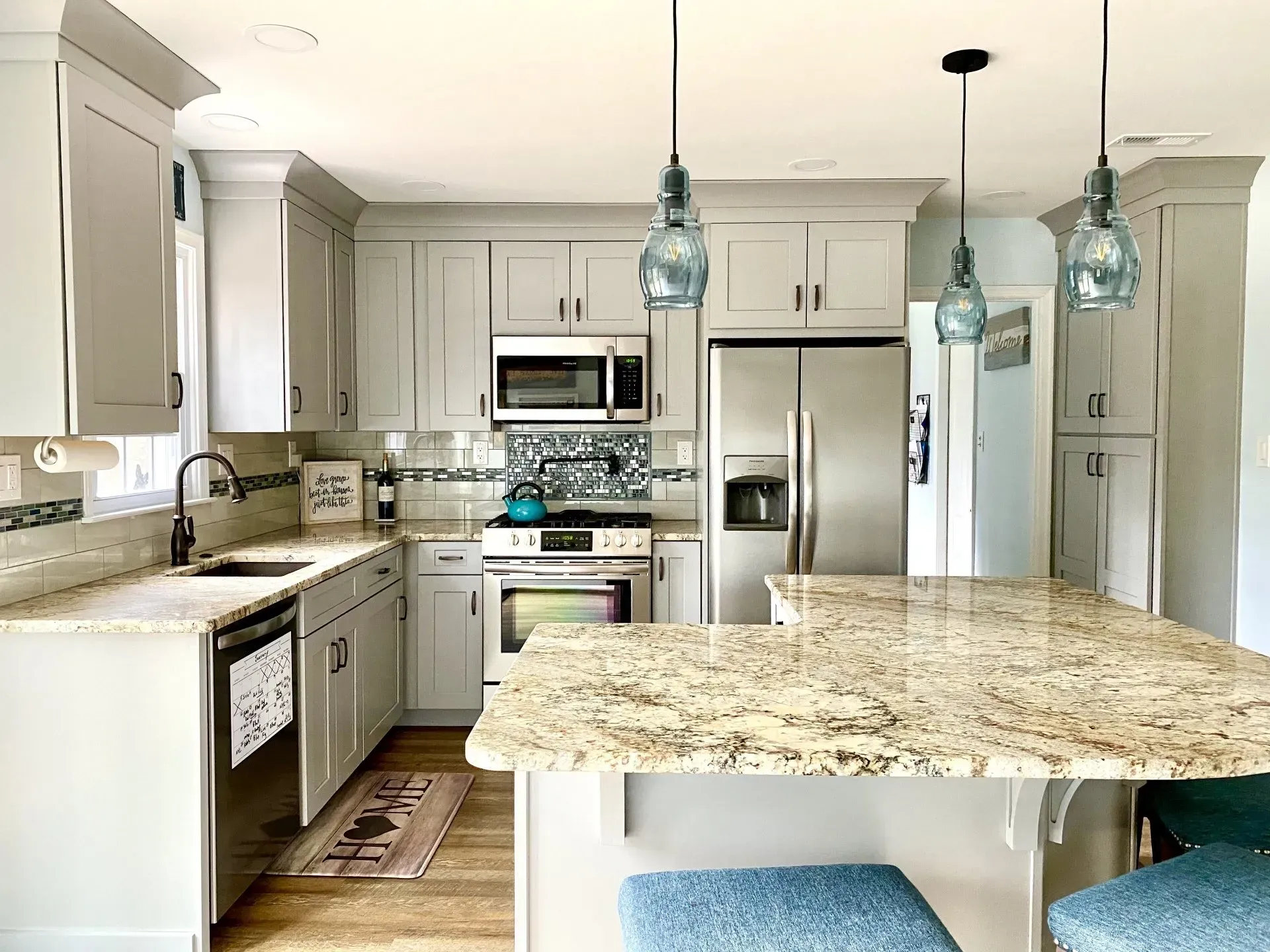 Bright modern kitchen with white cabinets, stainless appliances, and granite island countertops  In Bucks County PA