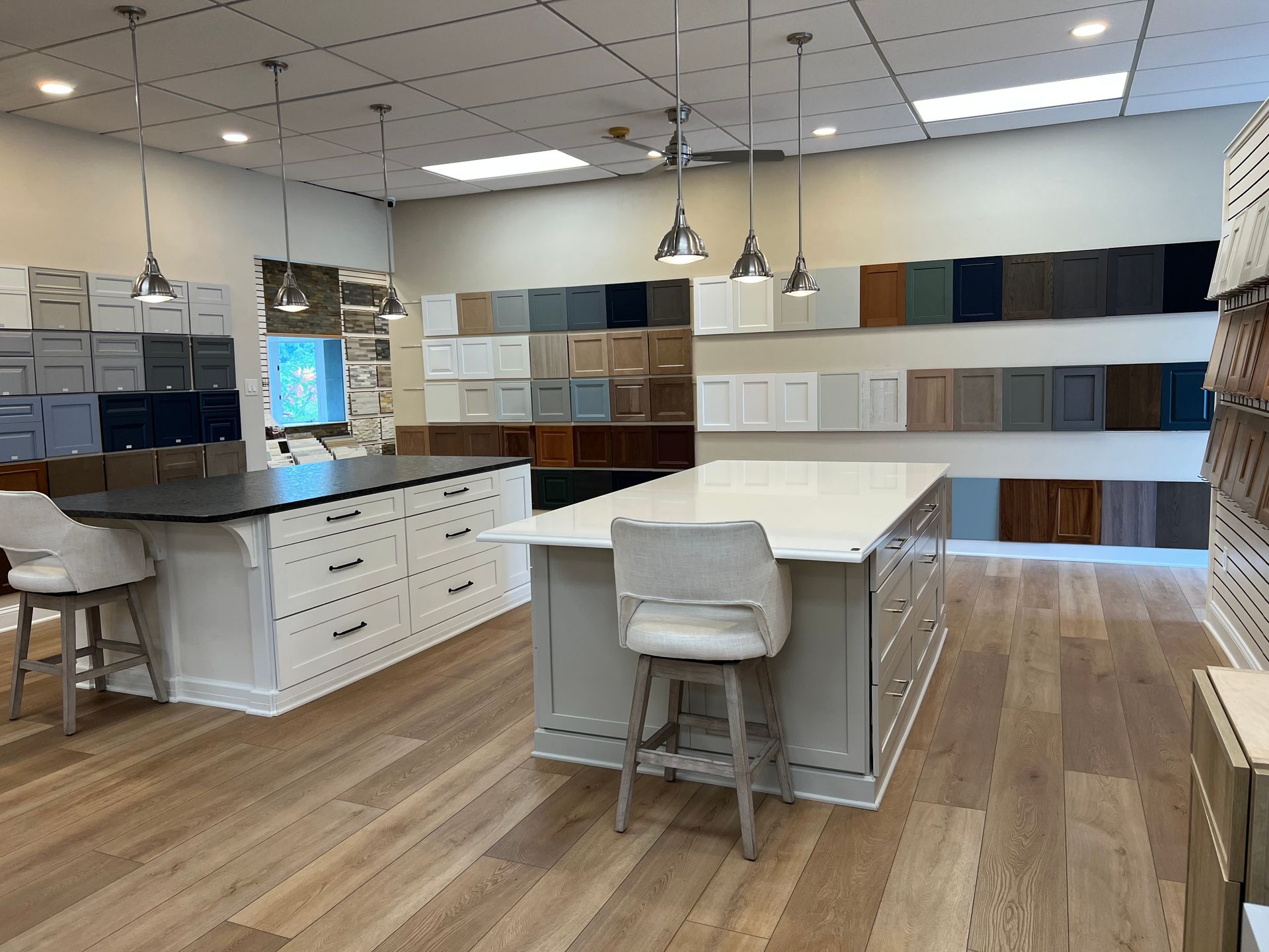 Empty retail showroom with wood flooring, central island displays, and ceiling fans under bright lights In Bucks Country PA