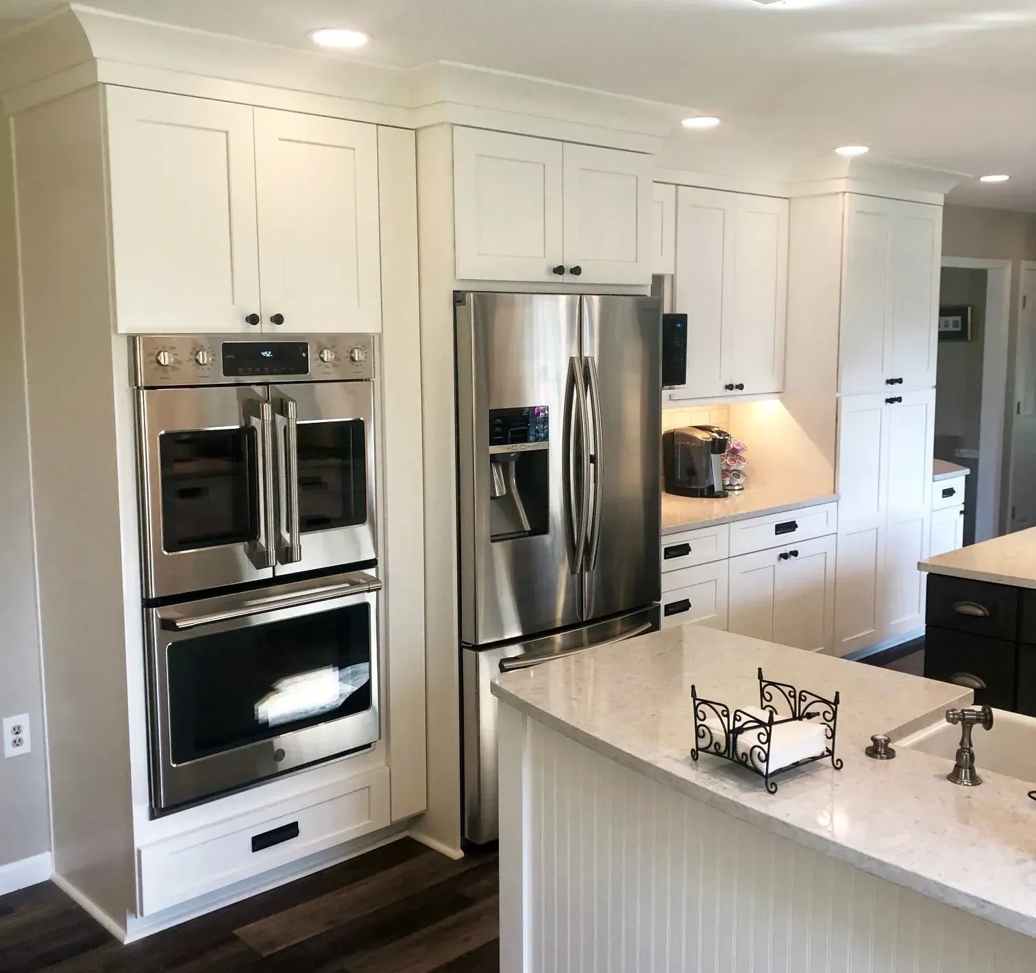 Bright white modern kitchen with stainless steel appliances, island, and built-in double ovens In Bucks County PA