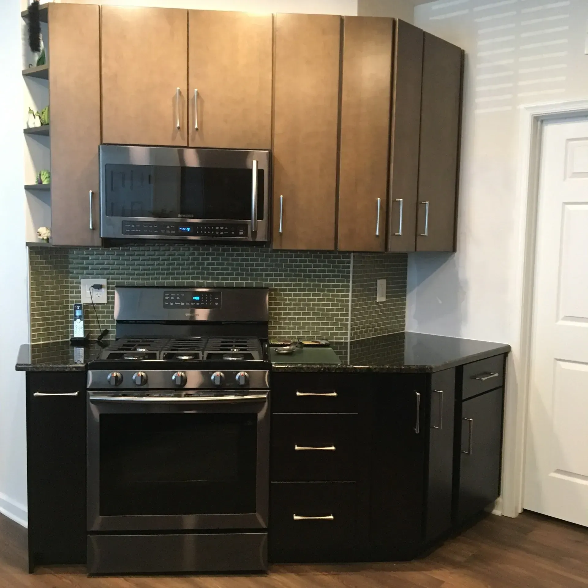 Modern kitchen with black appliances, dark counters, and wood cabinets corner layout  In Bucks County PA