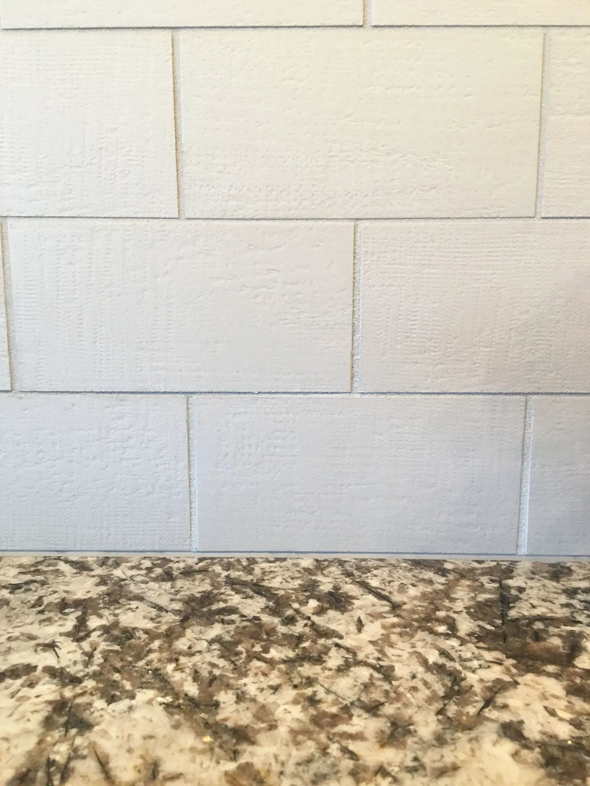 White cinderblock wall above a speckled granite countertop In Bucks County PA