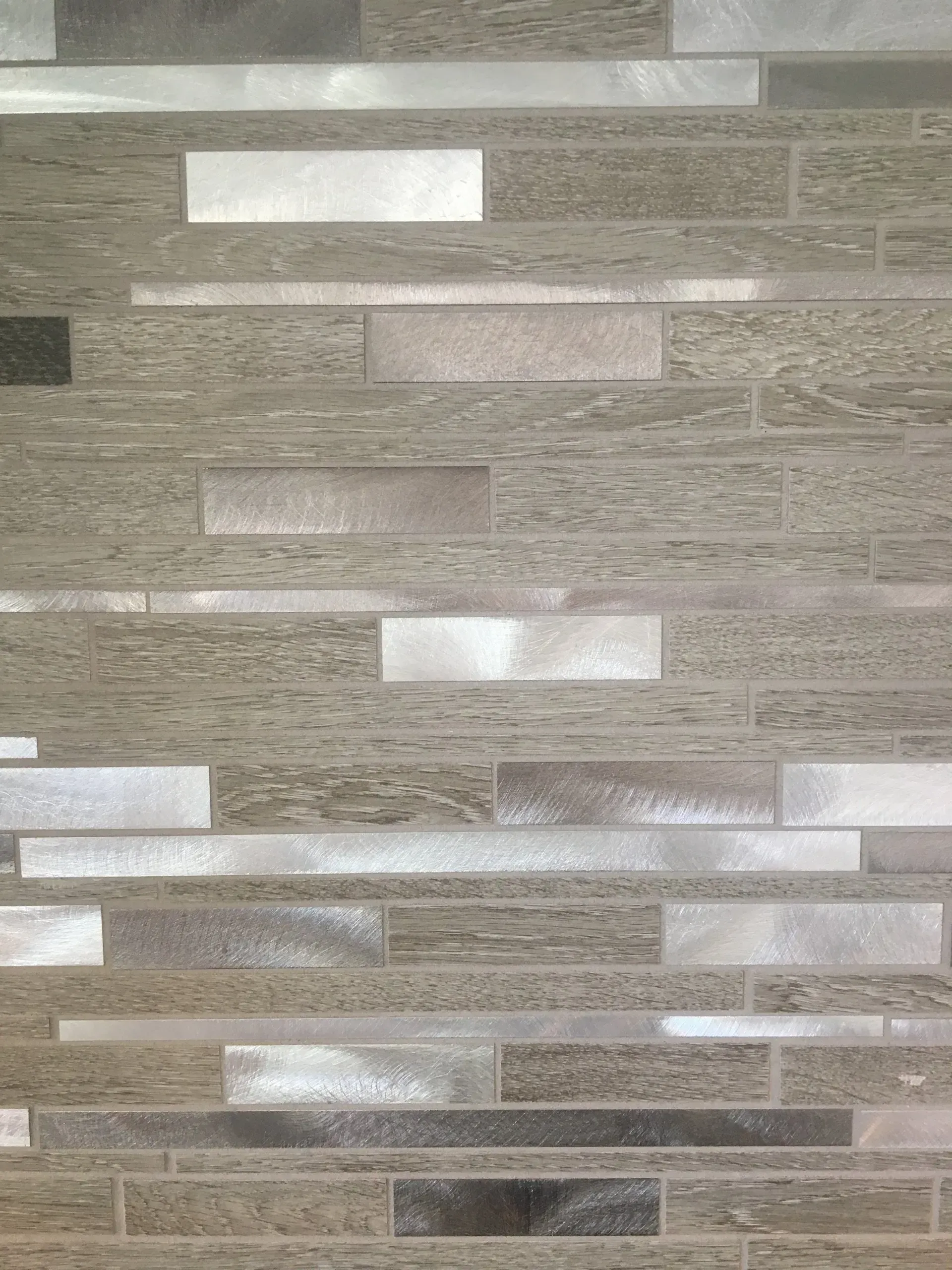 Gray and beige mosaic tile wall with horizontal rectangular stone strips In Bucks County PA