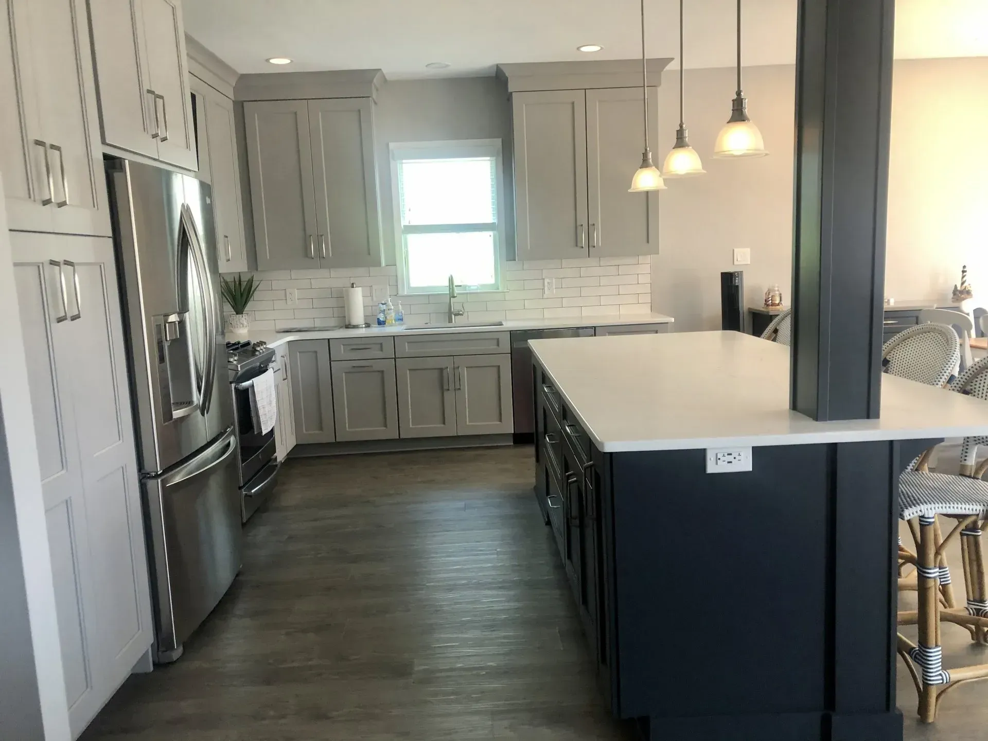 Modern kitchen with gray cabinets, stainless appliances, white island, and pendant lights In Bucks County PA