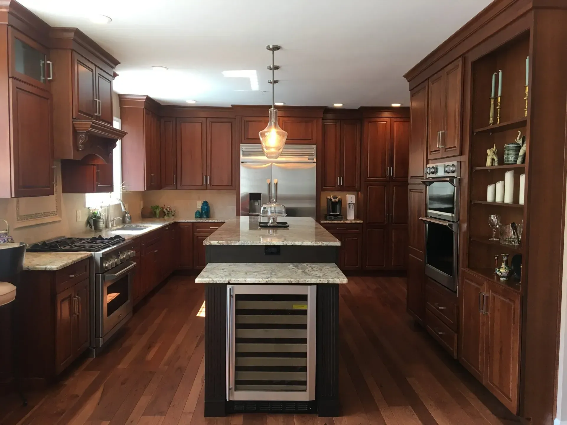Modern kitchen with dark wood cabinets, central island, granite countertops, and stainless steel appliances In Bucks Country PA