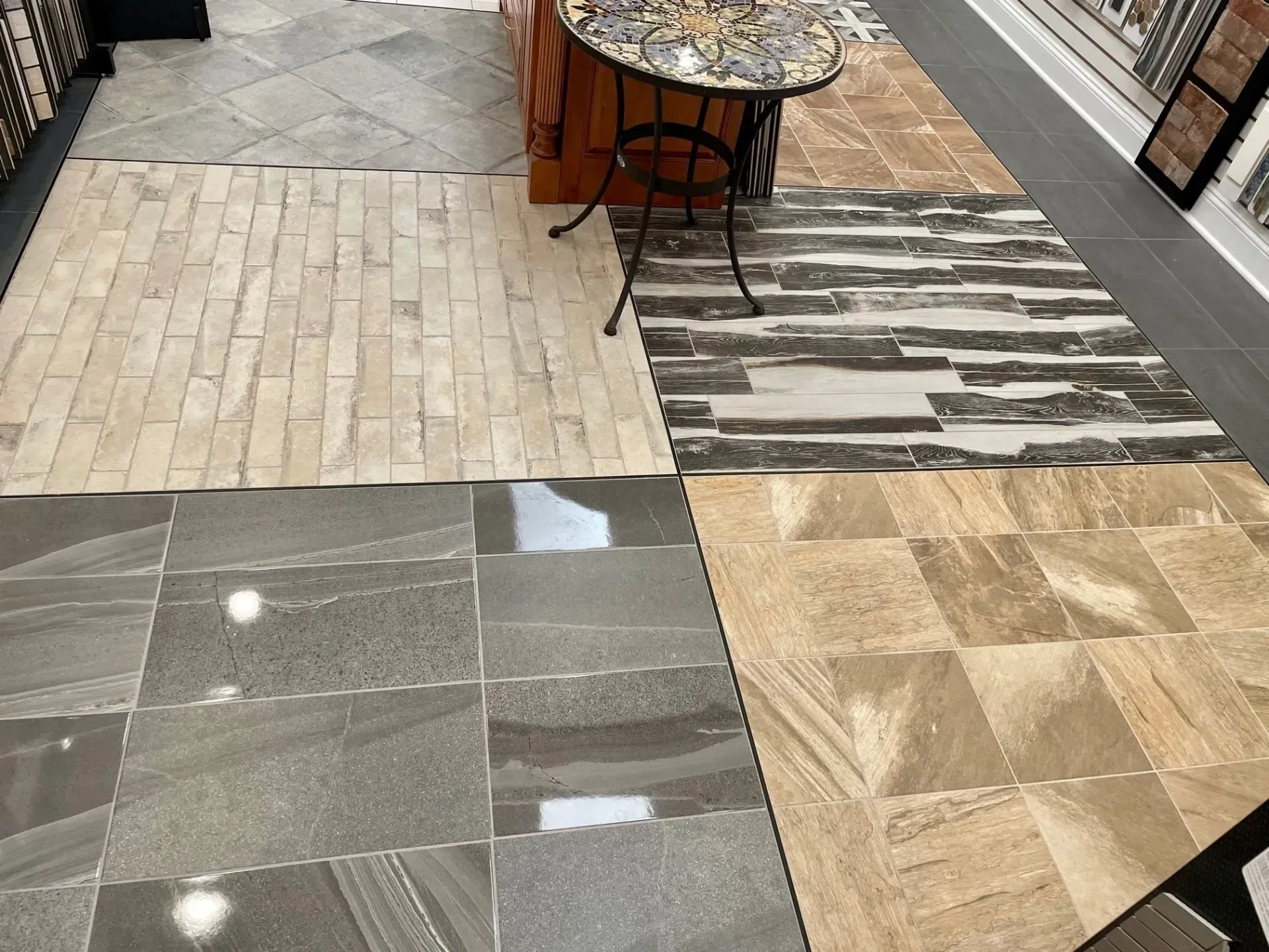 Patterned tile flooring display with gray, beige, and wood-look samples in a showroom corridor  In Bucks County PA
