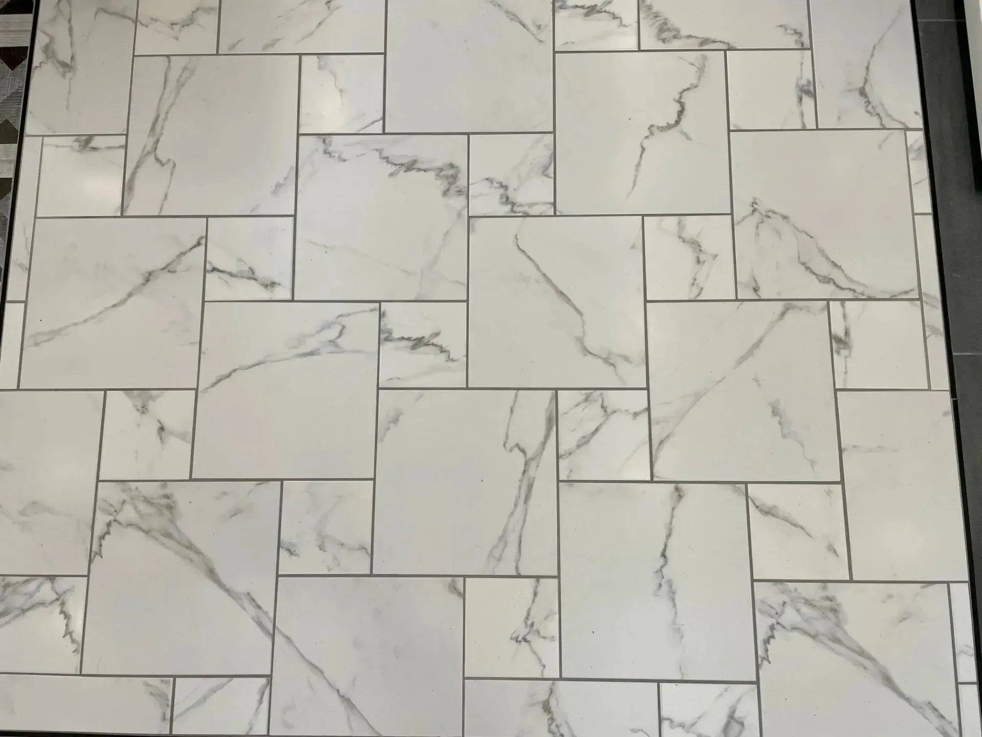 White marble-look tile floor with gray veining in a staggered rectangular pattern  In Bucks County PA