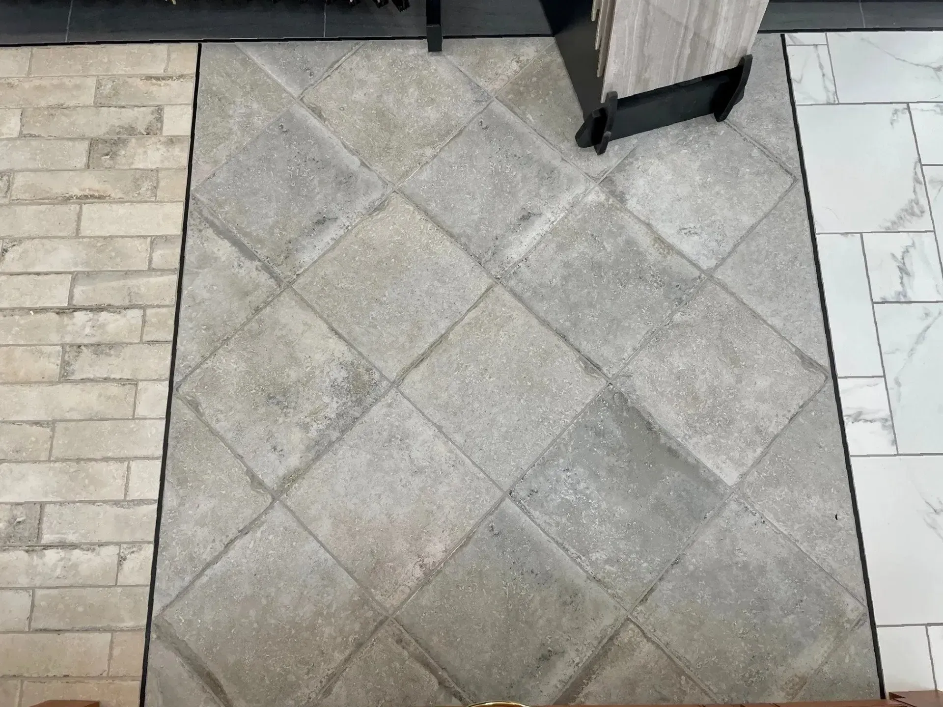 Gray tiled floor with a diagonal diamond pattern, bordered by light stone tiles and a door threshold  In Bucks County PA