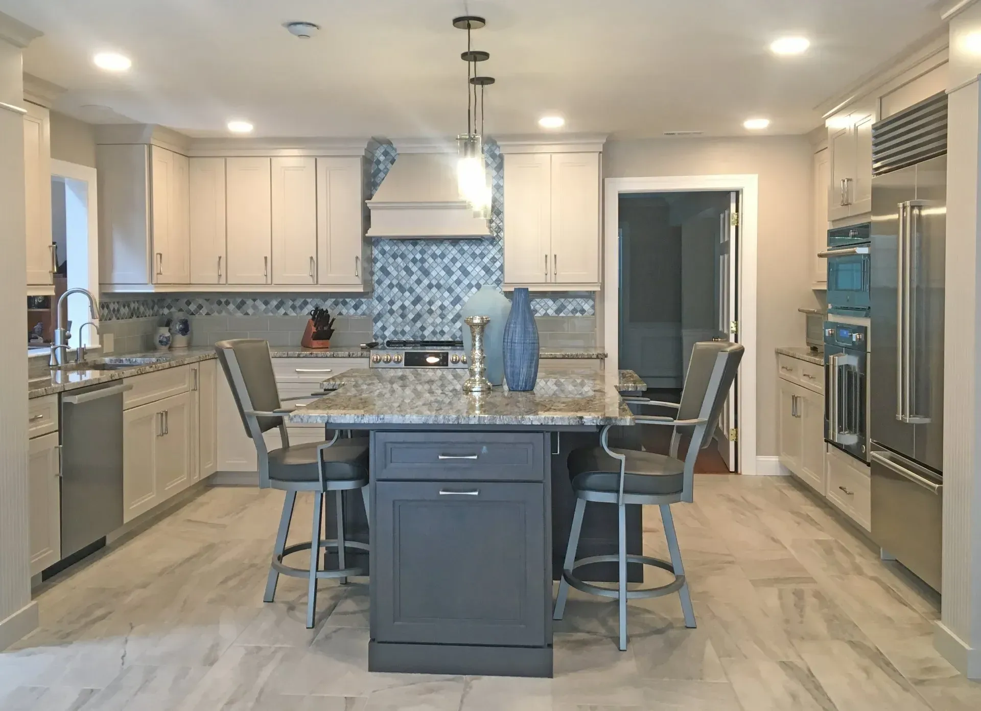 Modern kitchen with white cabinets, gray island, and stainless steel appliances In Bucks Country PA