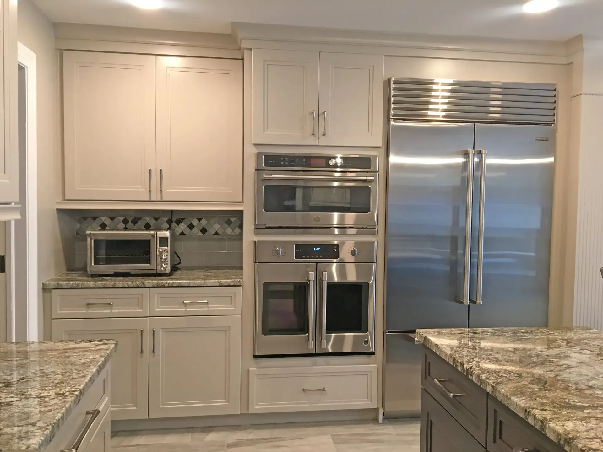Modern kitchen with white cabinets, stainless steel appliances, and granite countertops  in Bucks County PA