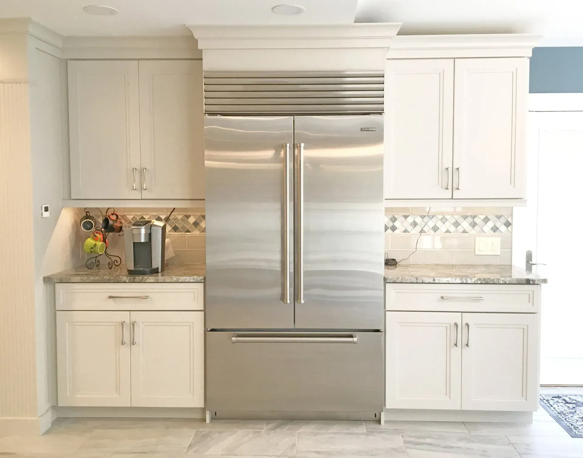 Bright kitchen with a stainless steel fridge, white cabinets, and light tile backsplash  in Bucks County PA