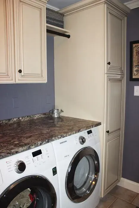 Laundry room with white cabinets, granite countertop, and a front-loading washer and dryer  In Bucks County PA