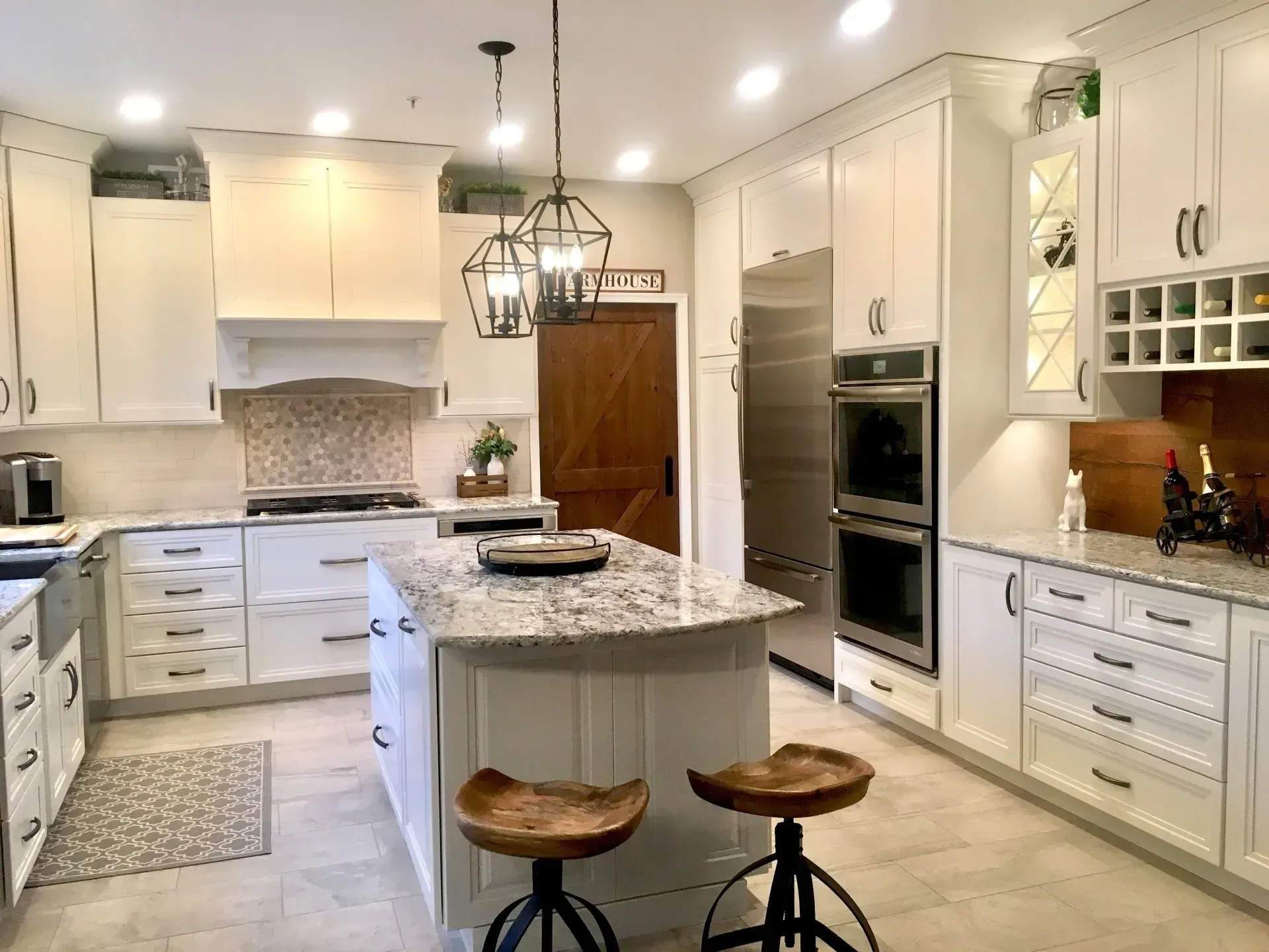 Bright white kitchen with granite island, pendant light, and built-in double ovens In Bucks County PA