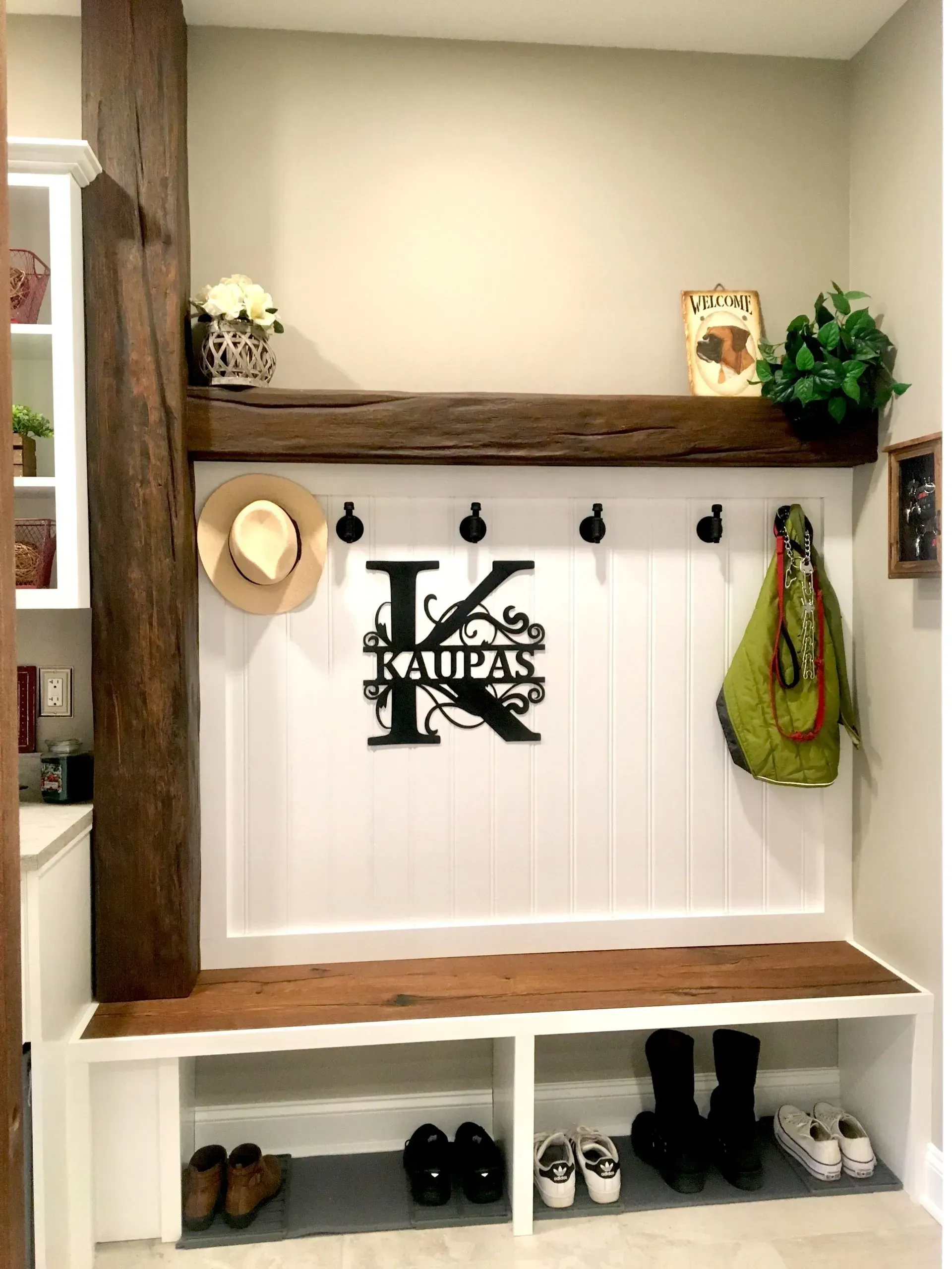 Rustic entryway bench with hooks, white beadboard, wood shelves, and shoes stored below In Bucks County PA