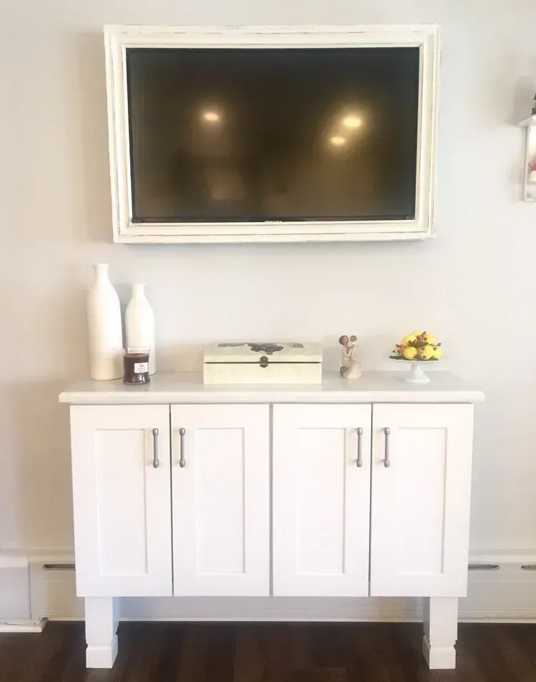 White cabinet with decor and a wall-mounted TV in a bright room In Bucks Country PA