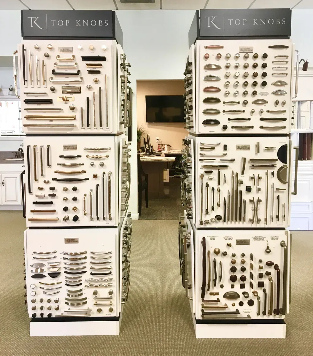 Display of knives and utensils on white wall panels in a kitchen showroom, with a doorway centered between them In Bucks County PA