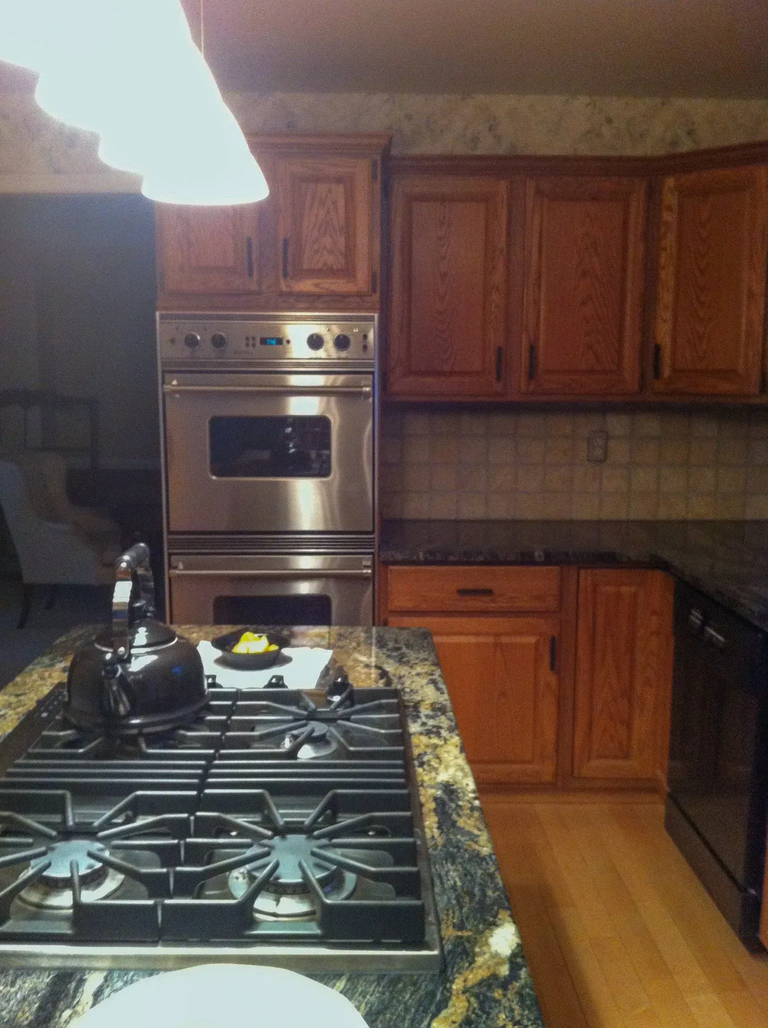 Kitchen with wooden cabinets, stainless steel oven, gas stove, and granite countertops In Bucks Country PA