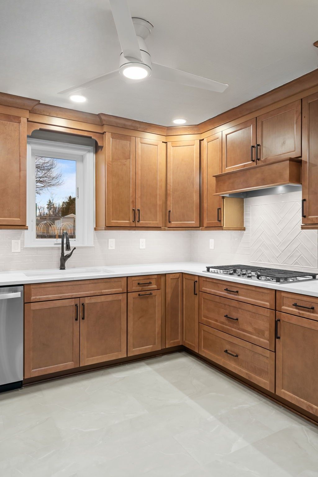 Empty kitchen with wooden cabinets, white countertops, stainless appliances, and a window over the sink  In Bucks County PA