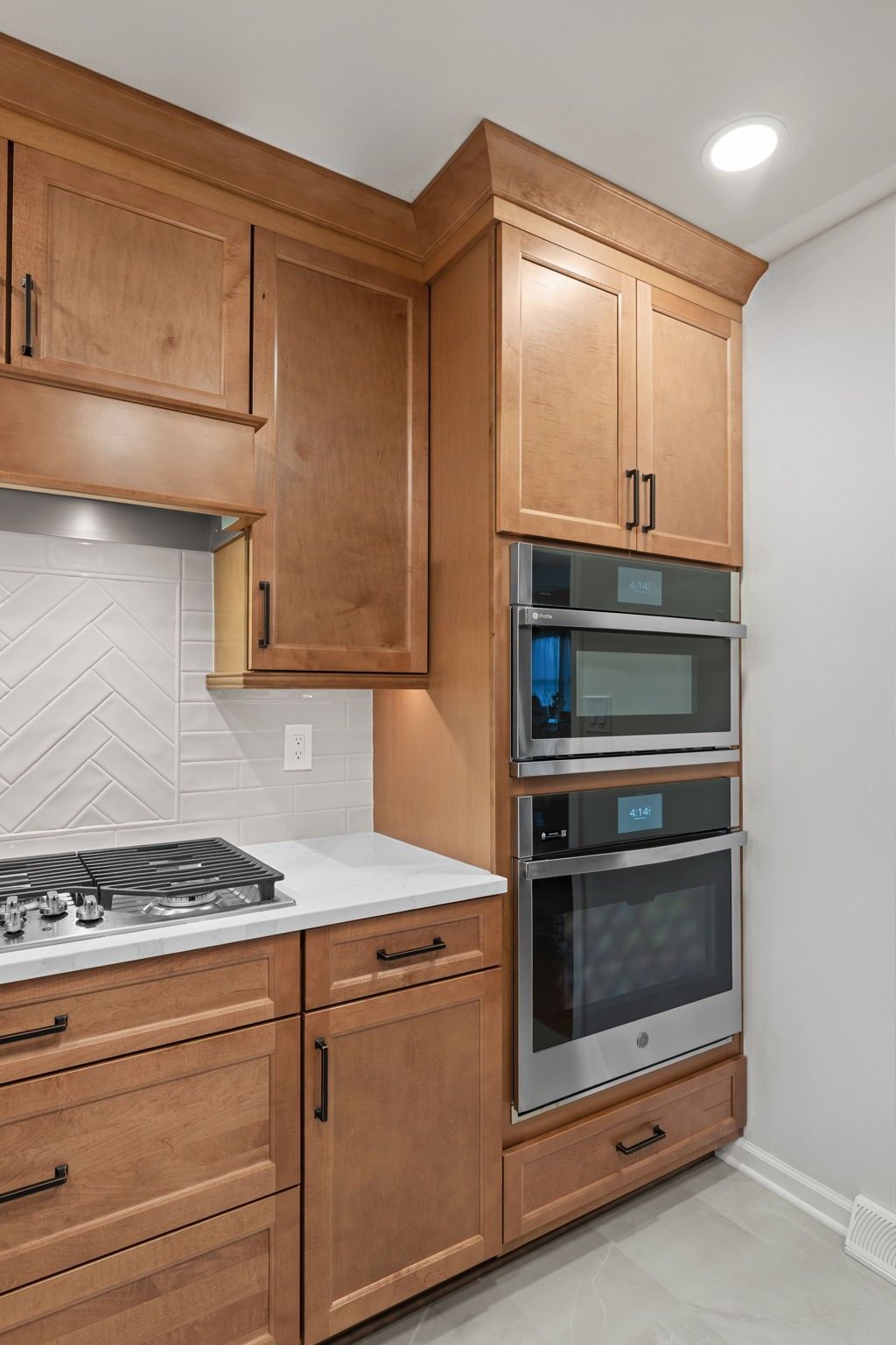Built-in kitchen cabinets with oven, microwave, and stove in a light wood finish  In Bucks County PA