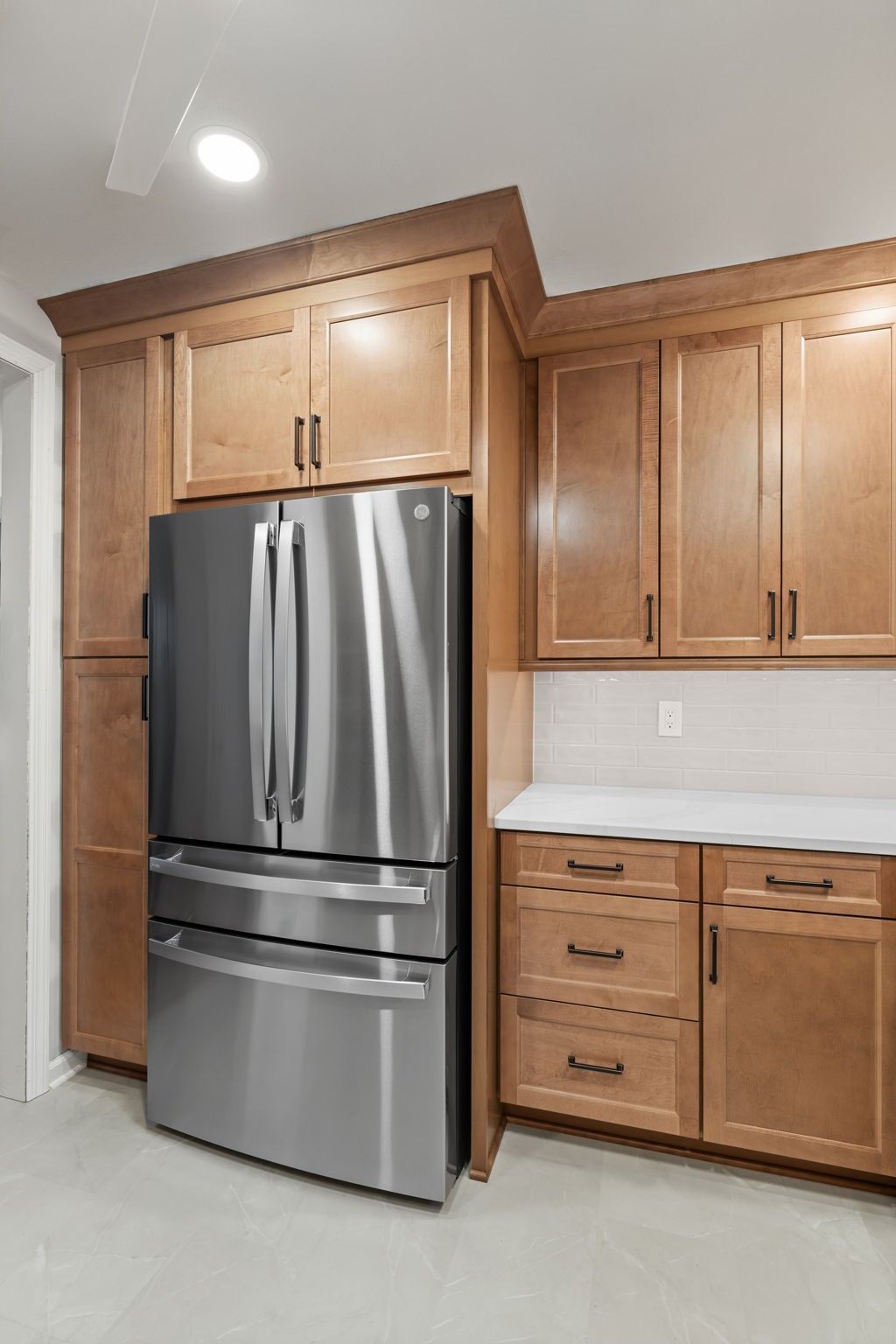Kitchen with stainless steel refrigerator, wood cabinets, and light countertops  In Bucks County PA