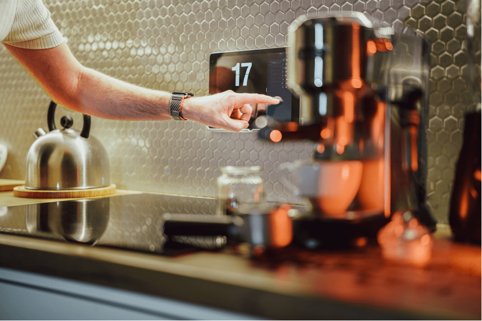 Barista reaching for an espresso machine in a warm-lit café counter area in Bucks Country PA