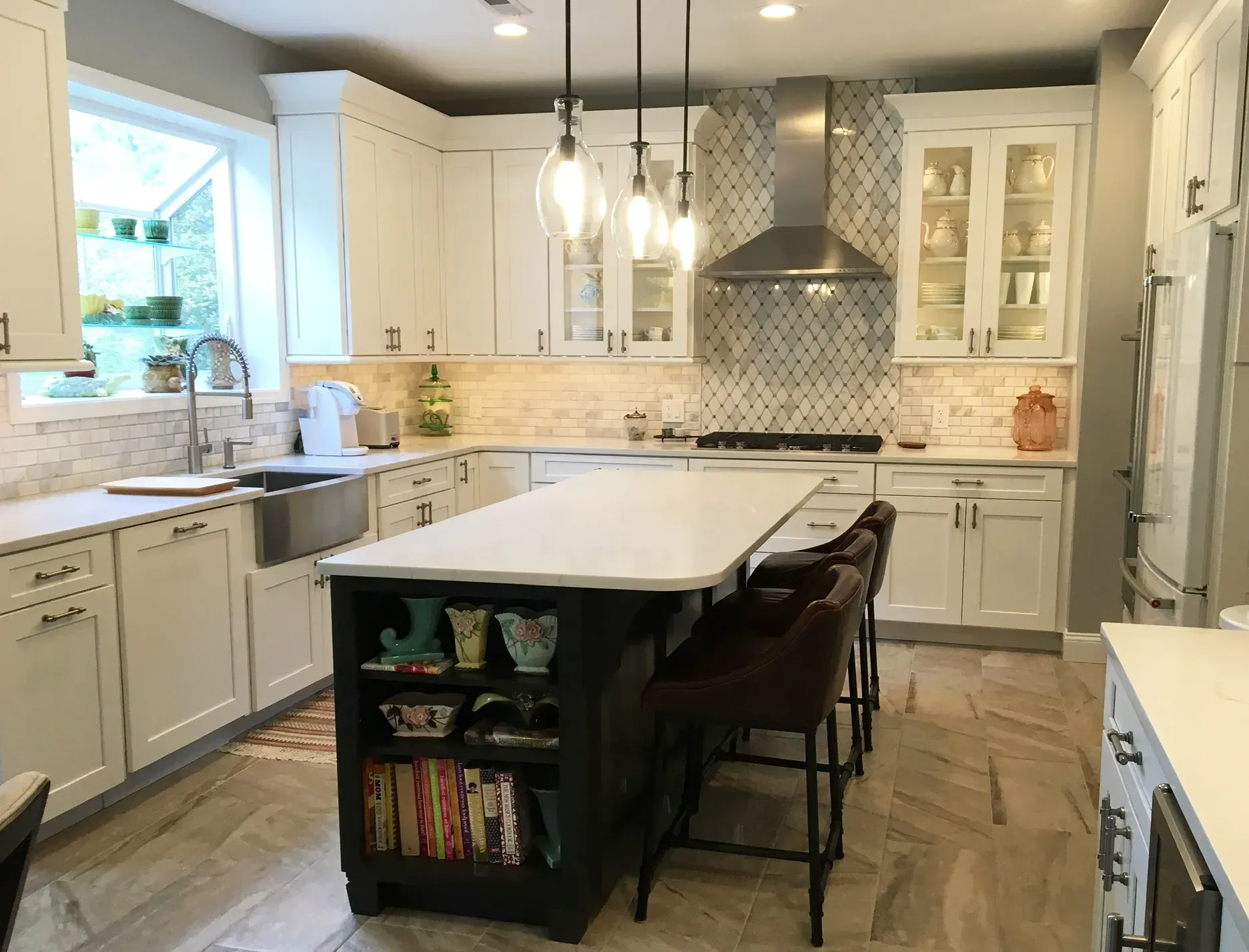 Bright modern kitchen with white cabinets, island, pendant light, and tiled backsplash In Bucks County PA