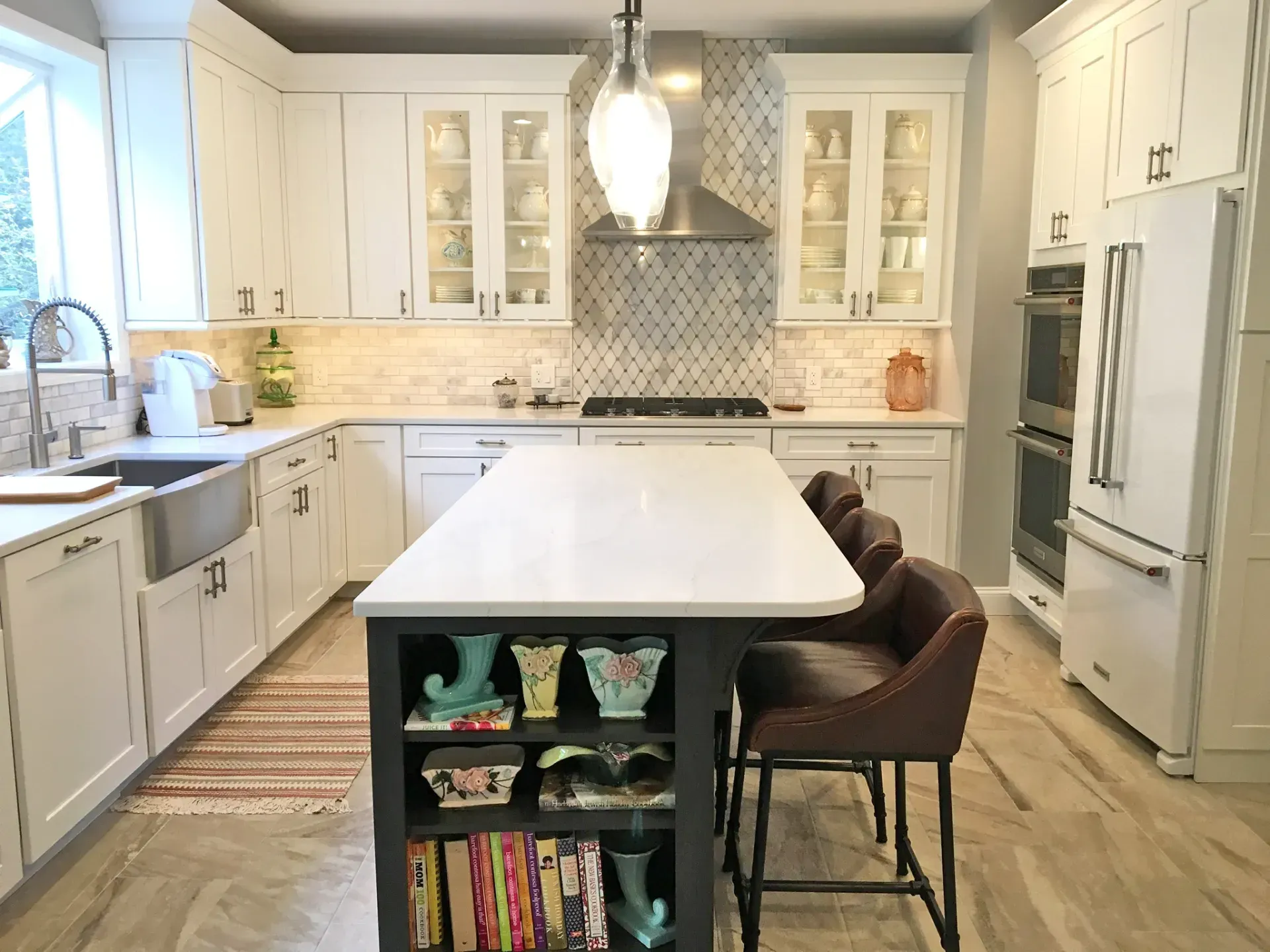 Bright white kitchen with island, pendant light, and two brown stools on wood floors In Bucks County PA