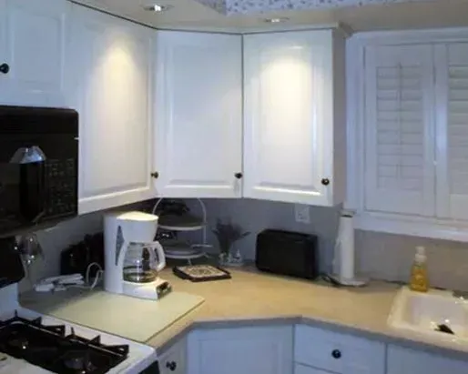 Bright kitchen with white cabinets, coffee maker, stove, sink, and small appliances on the counter  In Bucks County PA