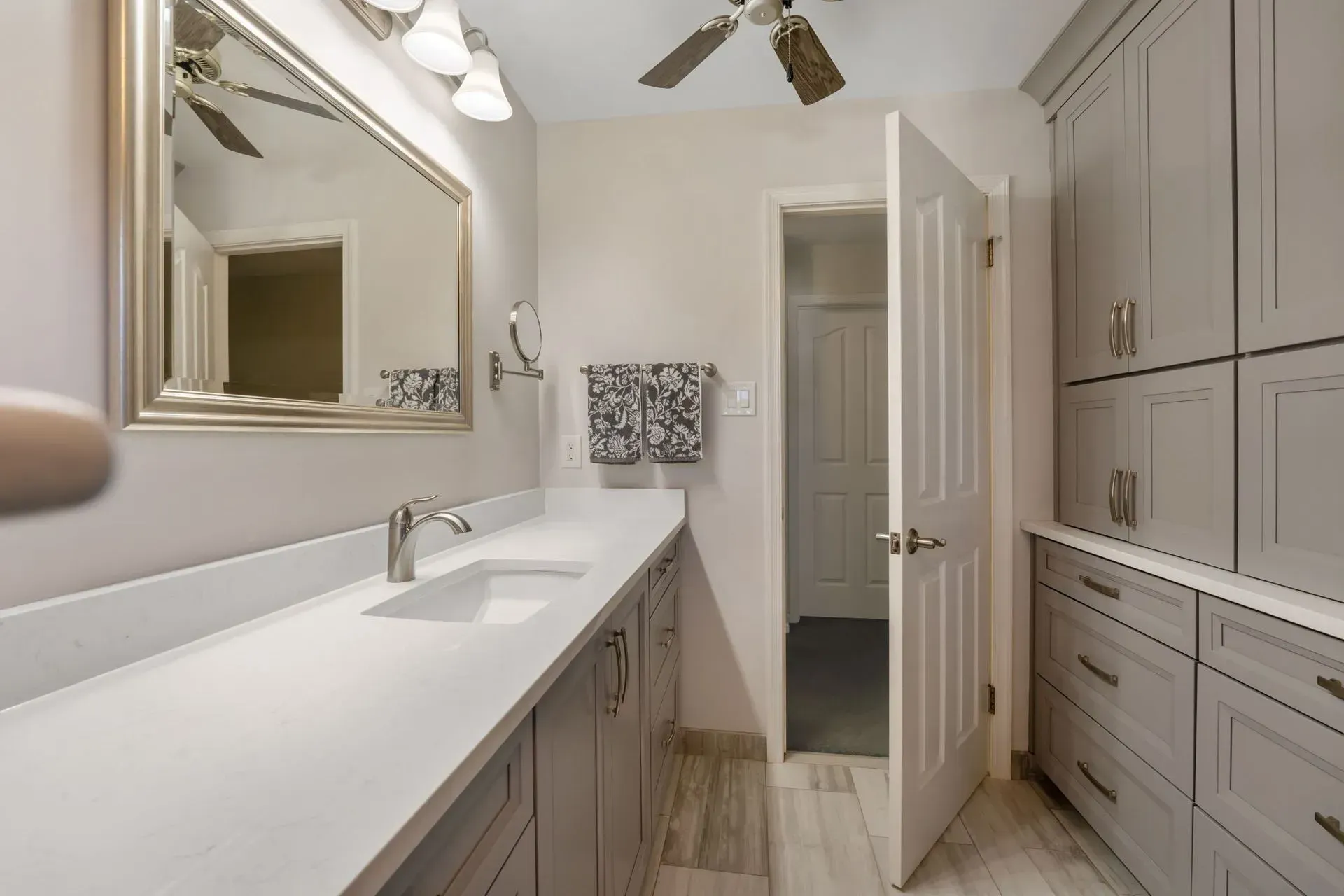 Modern white bathroom with double vanity, large mirror, and built-in cabinets In Bucks County PA