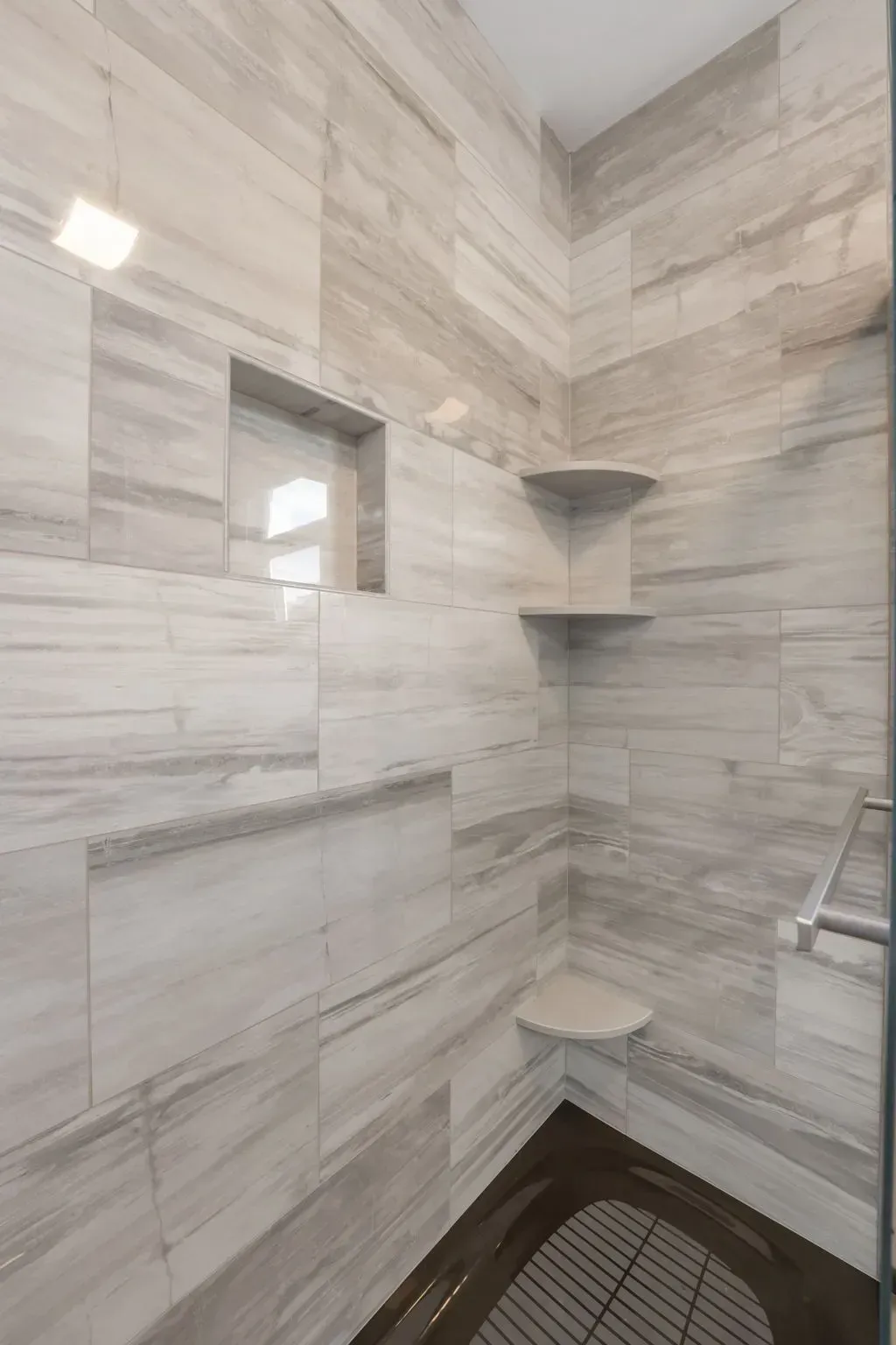 Tiled walk-in shower with corner shelves, small window, and dark floor drain area In Bucks County PA