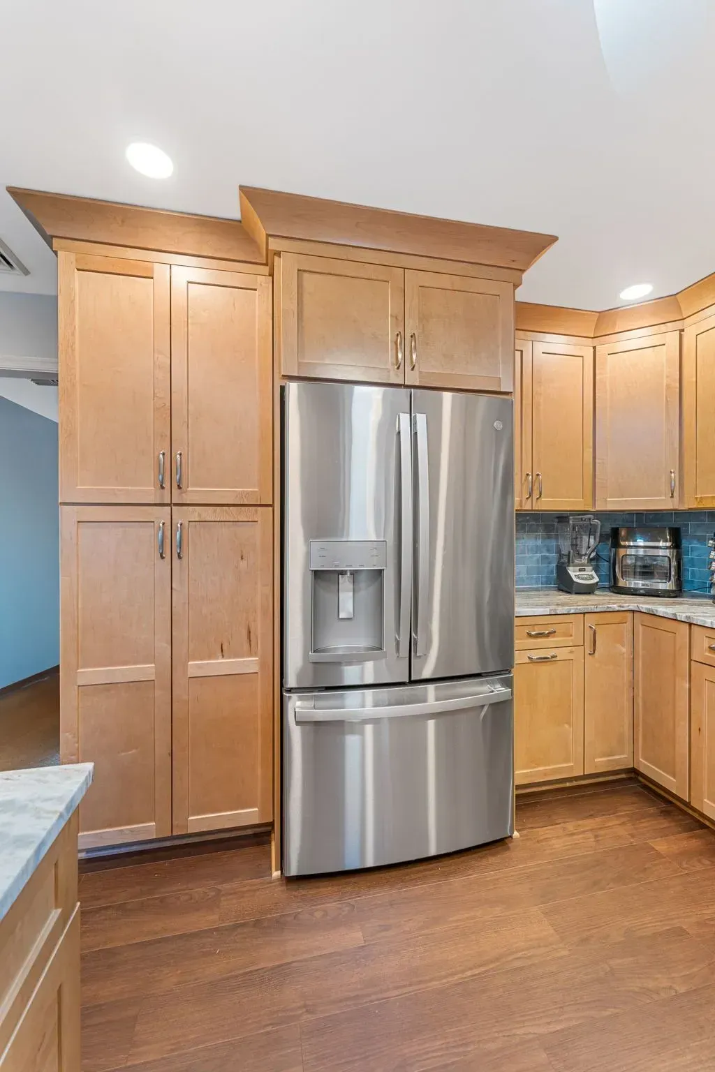 Kitchen with stainless steel refrigerator, light wood cabinets, and hardwood floor In Bucks Country PA