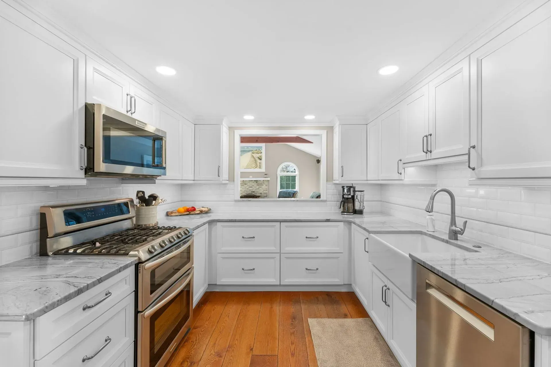 Bright white kitchen with marble counters, stainless appliances, and a window above the sink  In Bucks County PA 