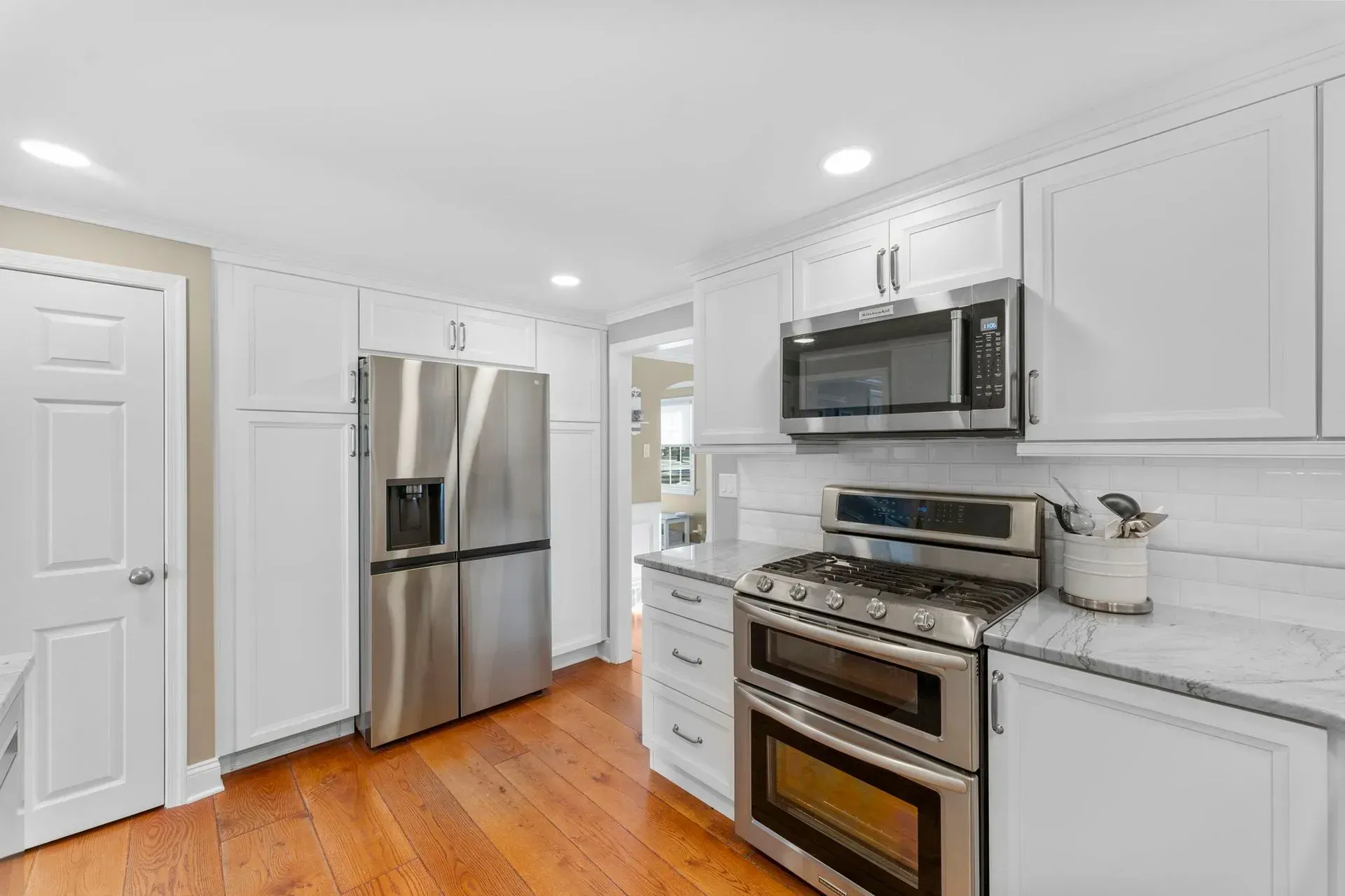 Bright white kitchen with stainless steel appliances and hardwood floors  In Bucks County PA