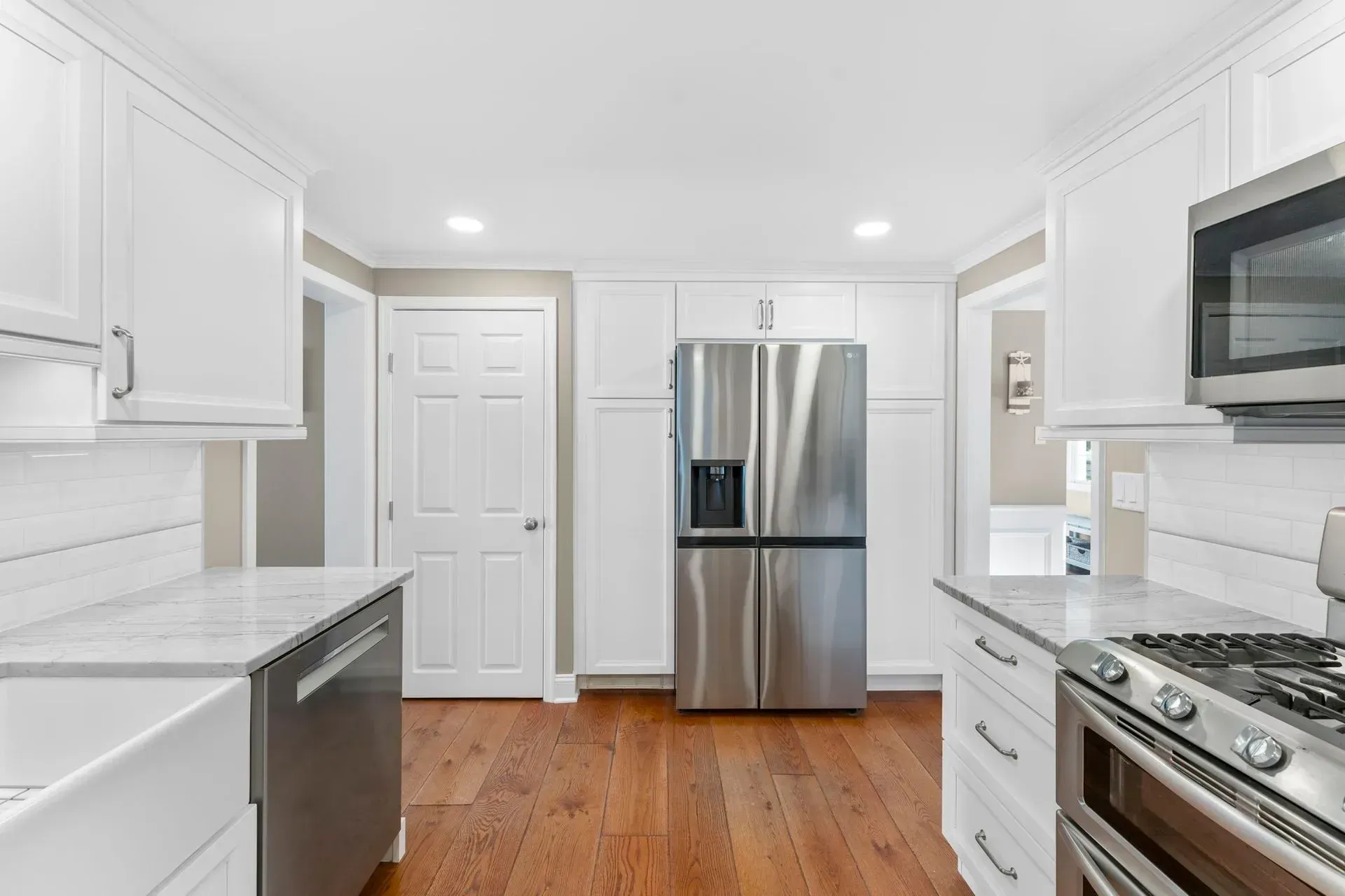 Bright white kitchen with stainless steel appliances and hardwood floors   In Bucks County PA