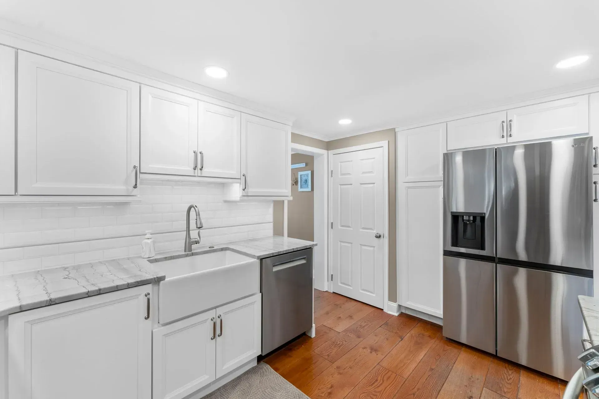 Bright white modern kitchen with stainless steel appliances and hardwood floors  In Bucks County PA