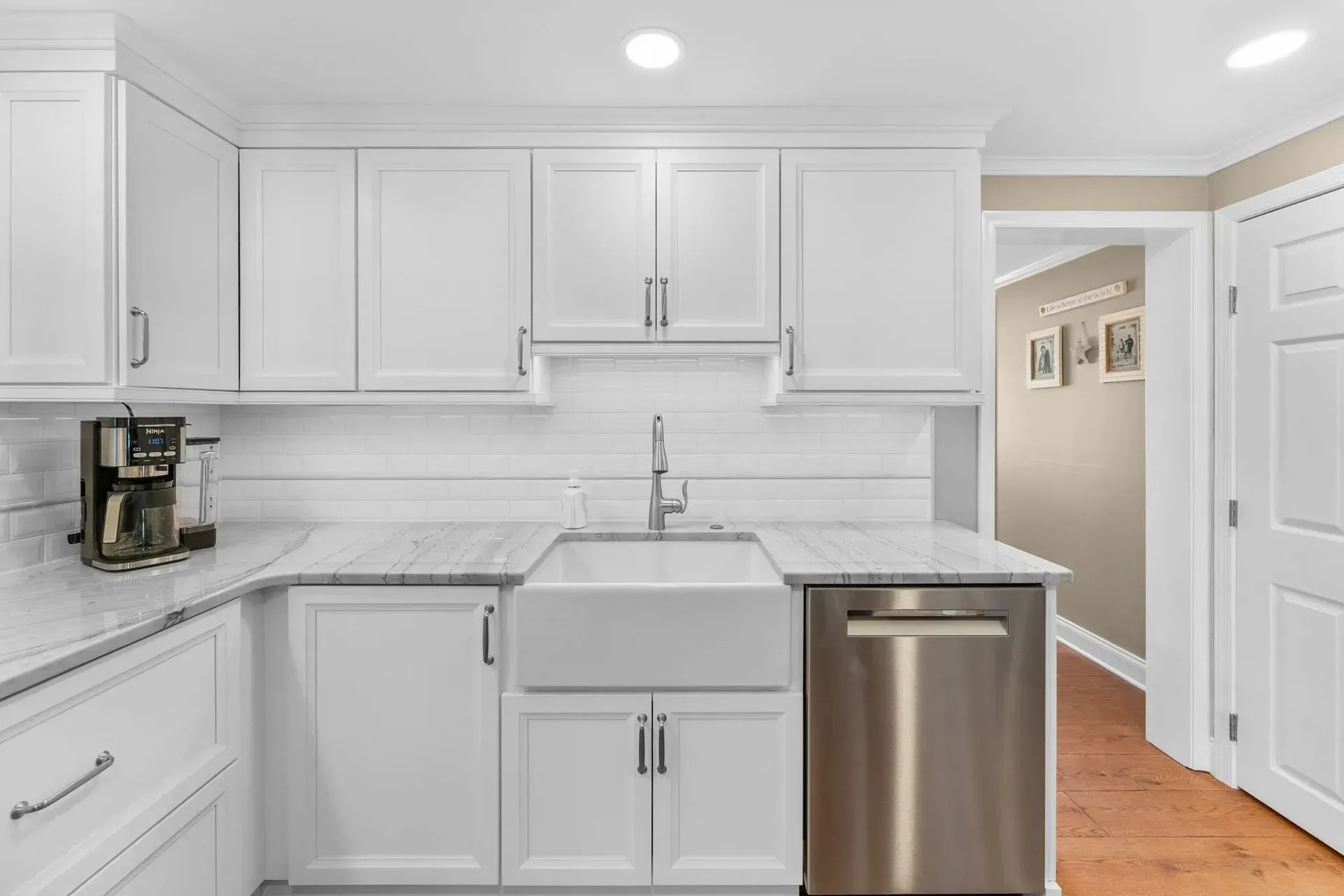 Bright white kitchen with cabinets, marble-look counters, sink, and stainless dishwasher  In Bucks County PA
