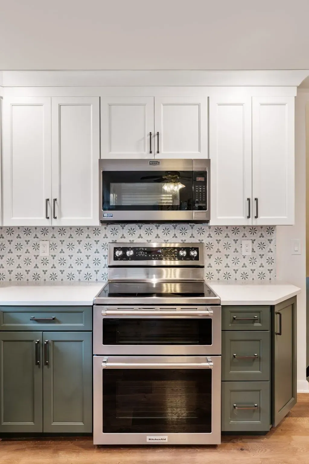 Modern kitchen with white cabinets, stainless steel appliances, and sage green lower cabinets  In Bucks County PA