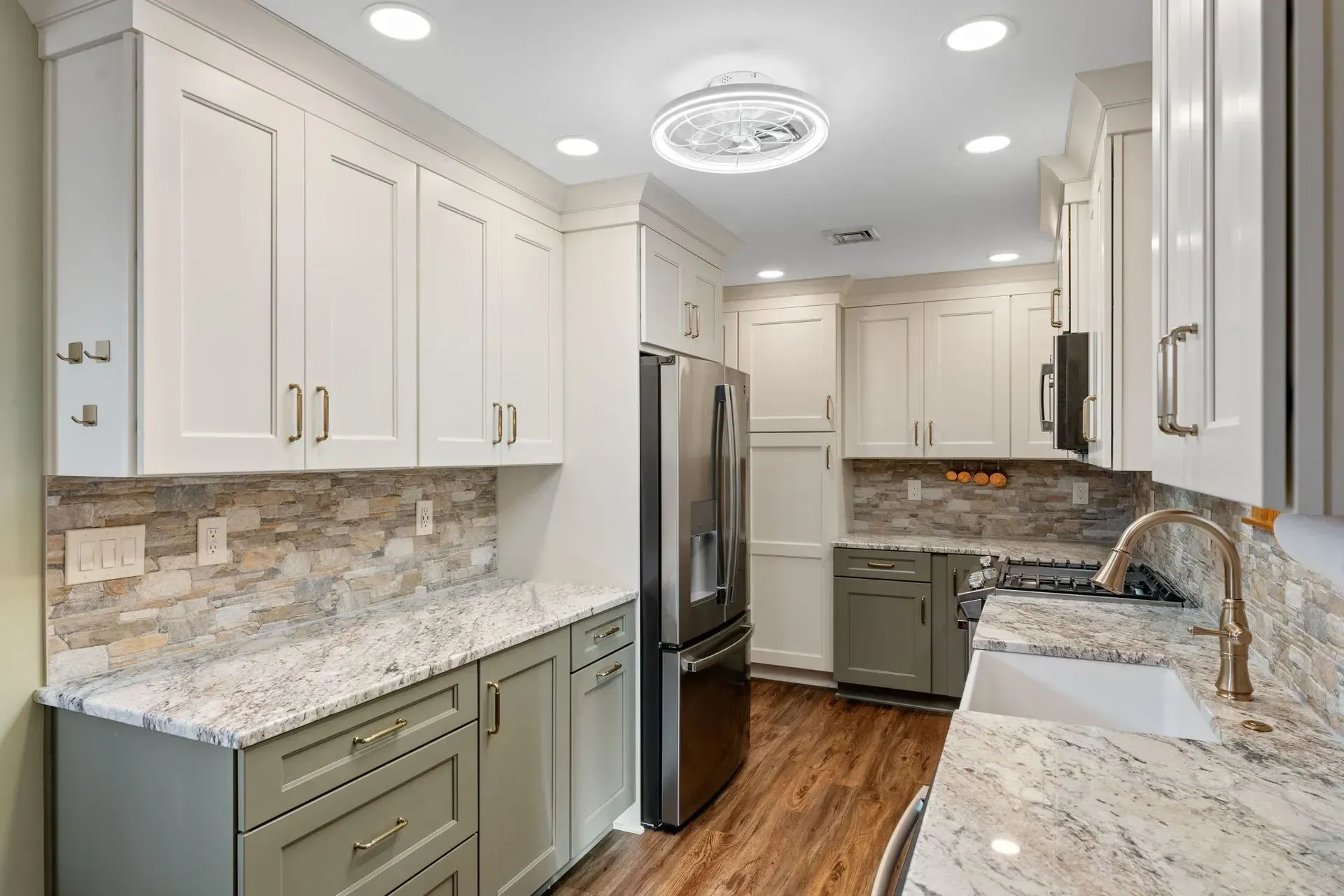 Bright modern kitchen with white cabinets, granite counters, stainless fridge, and wood floor In Bucks Country PA