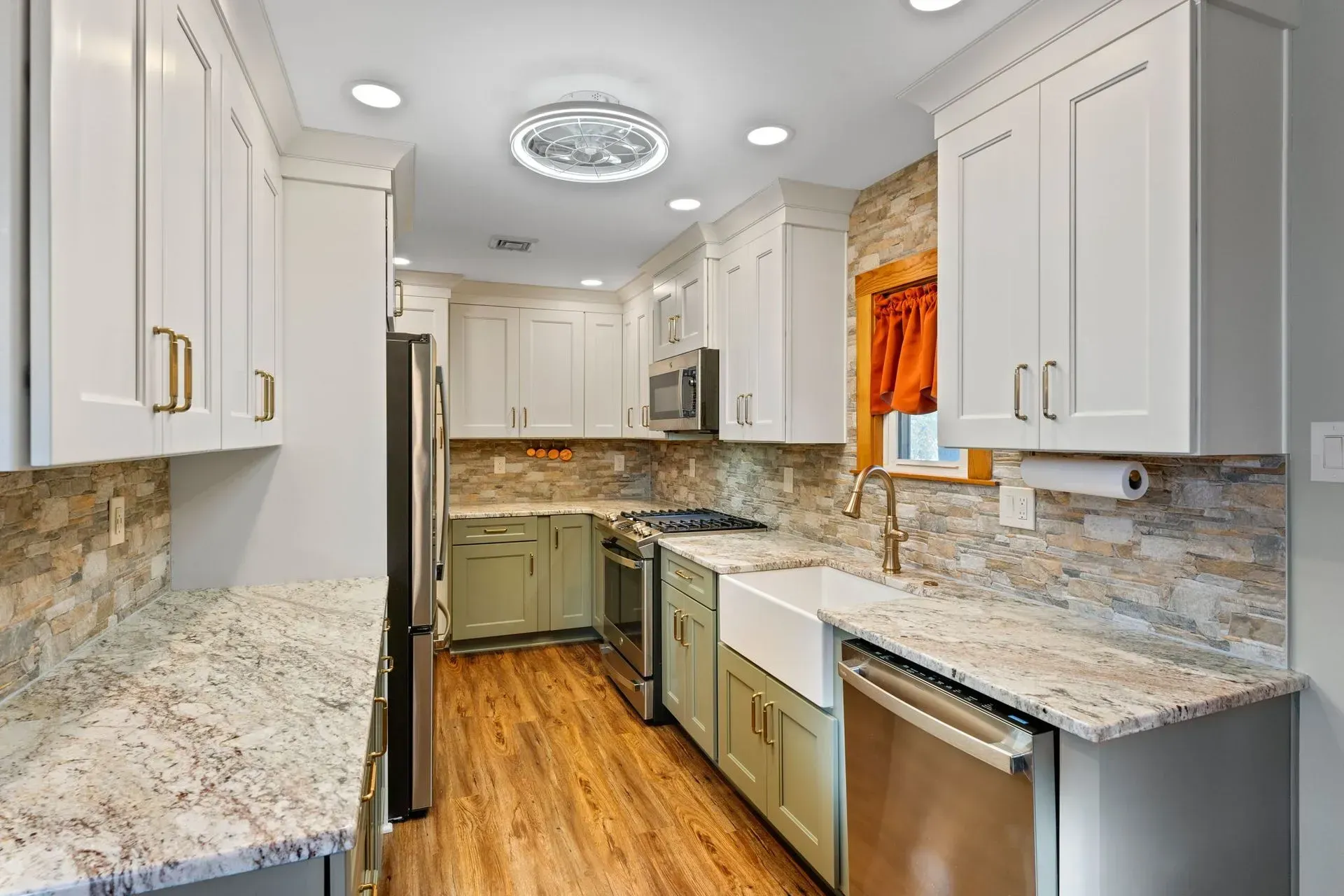 Bright modern kitchen with white cabinets, granite counters, stainless appliances, and wood floors In Bucks County PA