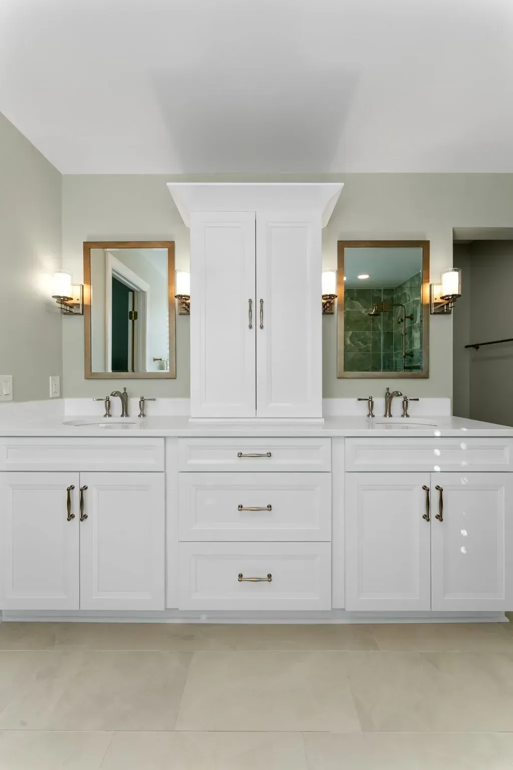 White double vanity bathroom with center storage cabinet, mirrors, and sconces In Bucks County PA