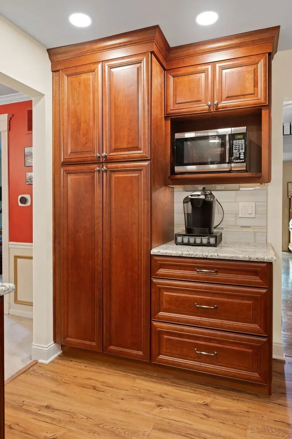 Built-in kitchen cabinet wall with wood finish, microwave, coffee maker, and drawers on a hardwood floor In Bucks Country PA