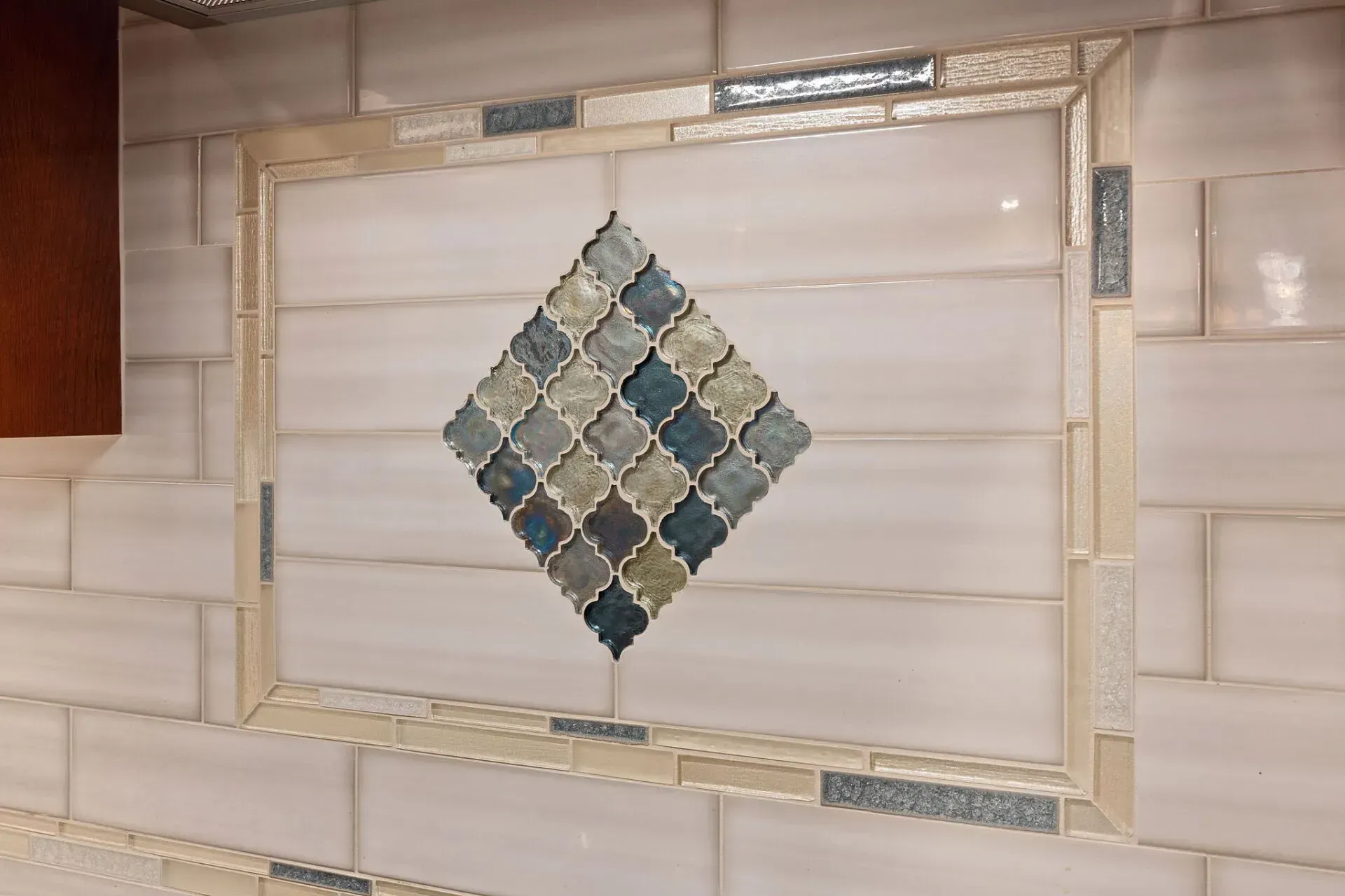 Decorative diamond tile mosaic centered on a beige tiled wall In Bucks Country PA