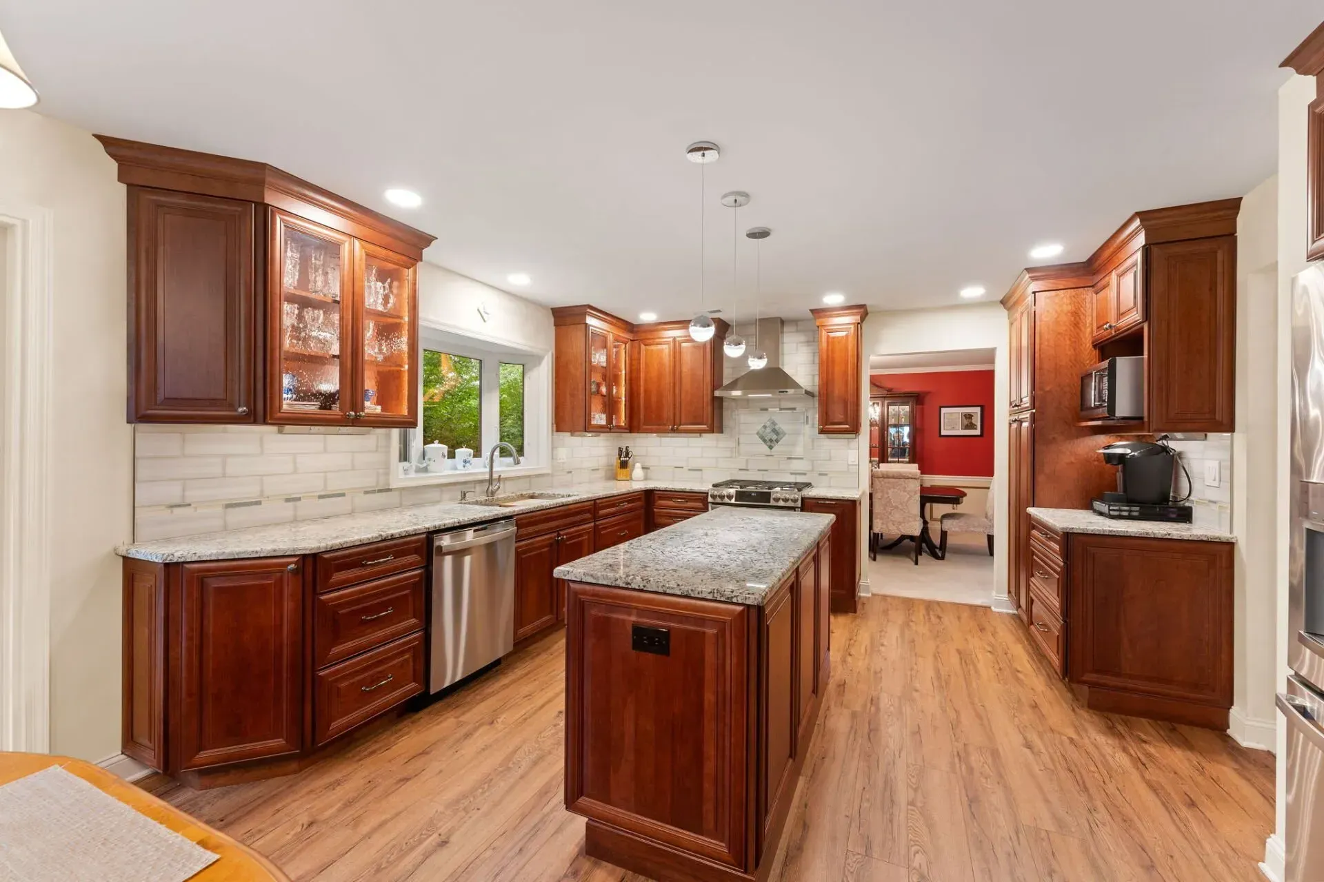 Bright modern kitchen with cherry cabinets, granite island, stainless appliances, and hardwood floors In Bucks Country PA