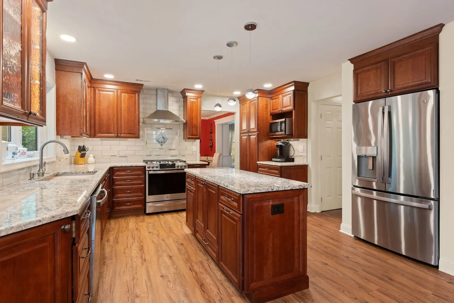 Spacious modern kitchen with wood cabinets, stainless steel appliances, granite island, and hardwood floors In Bucks Country PA