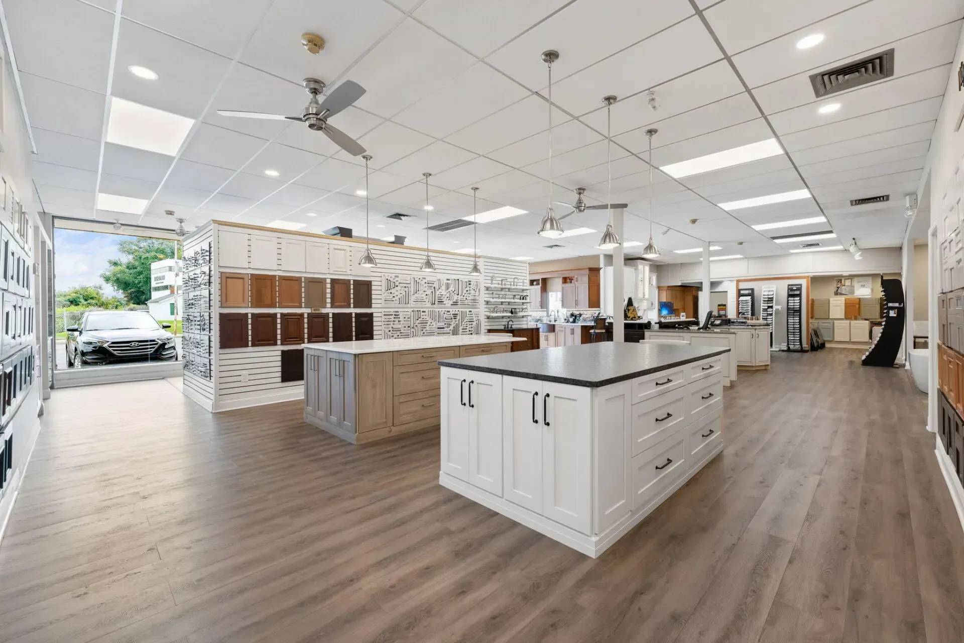 Bright modern kitchen showroom with white cabinets, island, and wood floors  In Bucks County PA