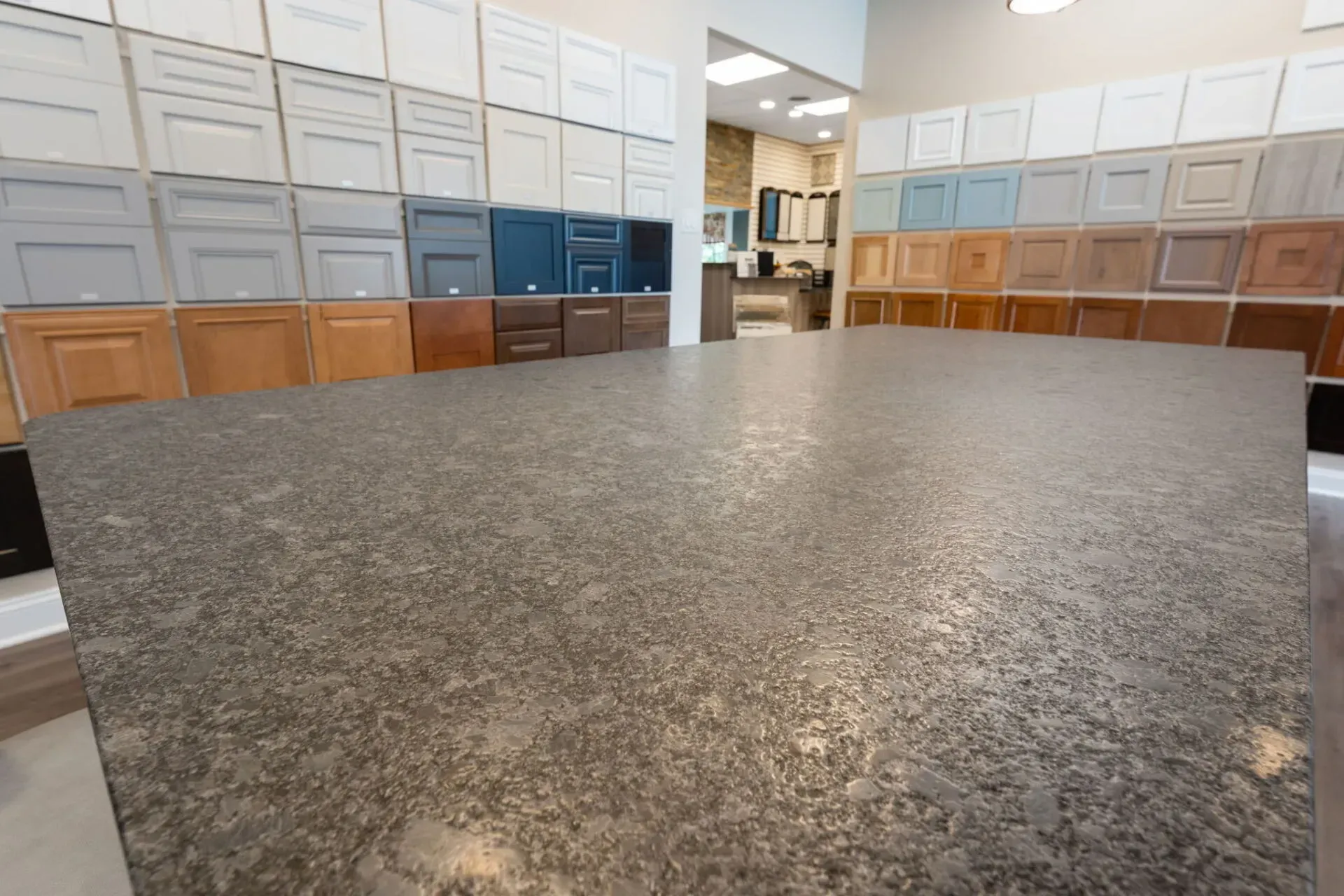 Kitchen showroom with granite countertop and rows of cabinet samples in the background  In Bucks County PA