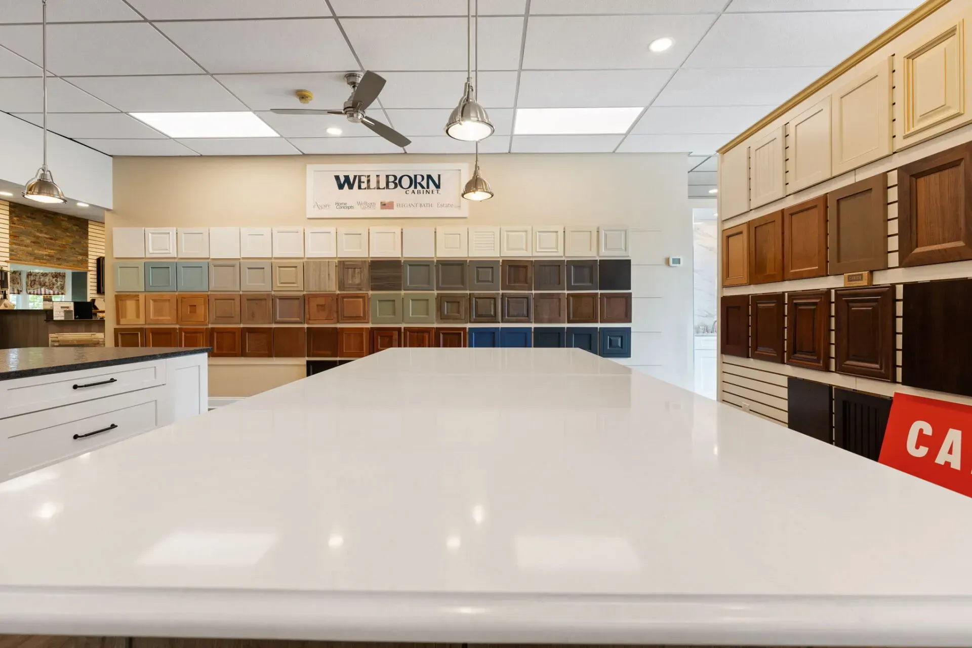Showroom with sample cabinets and a large white countertop under ceiling fans  In Bucks County PA