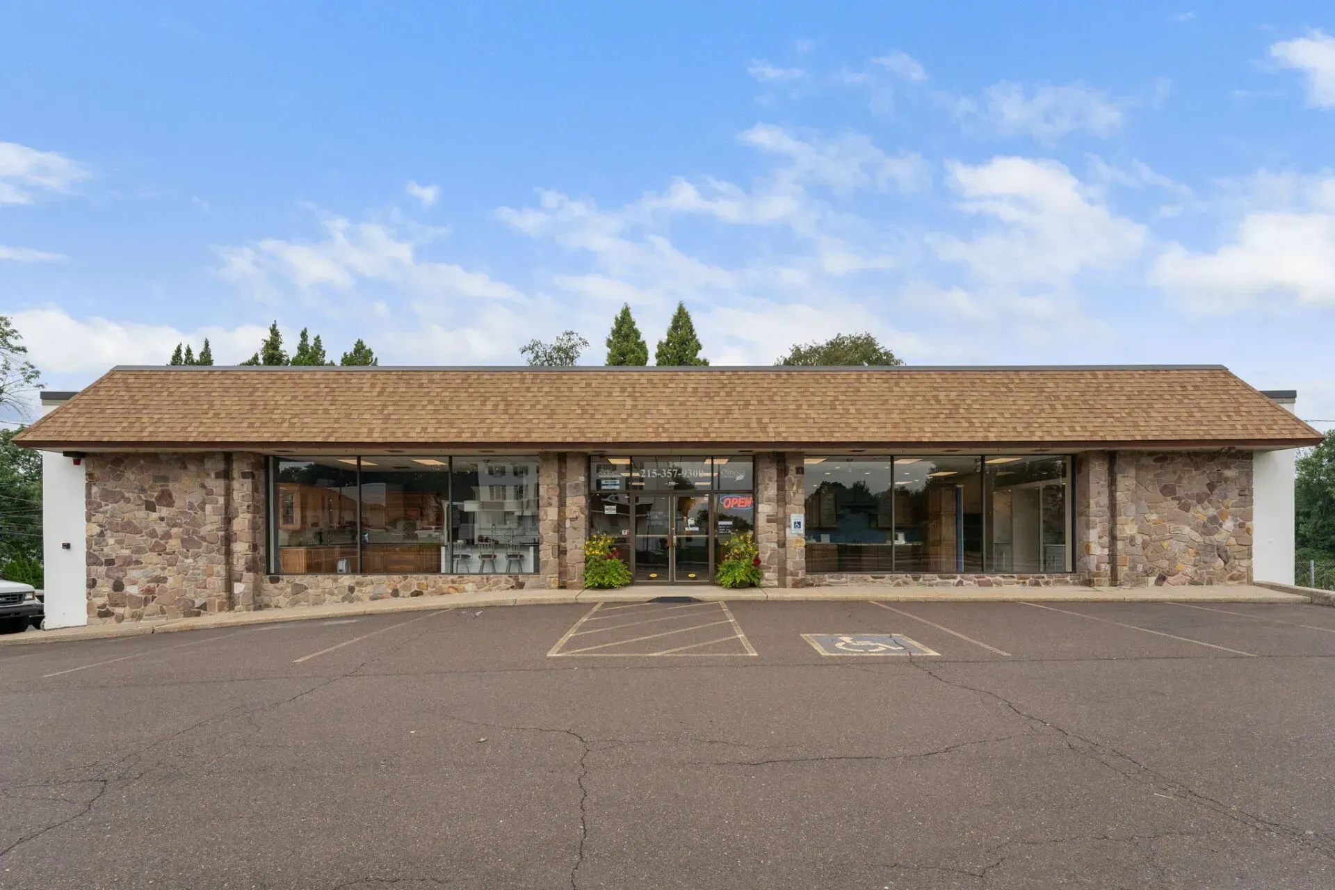 Low stone storefront with large windows and a parking lot under a blue sky  In Bucks County PA